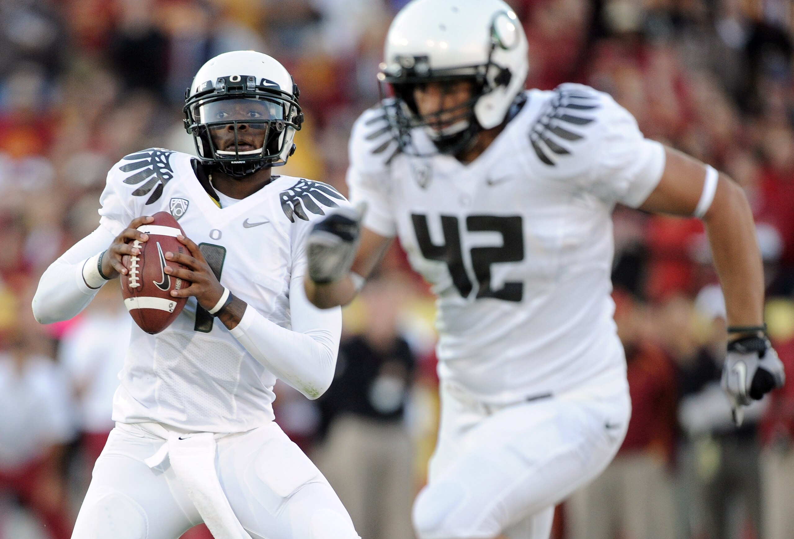 LOS ANGELES, CA - OCTOBER 30:  Darron Thomas #1 of the Oregon Ducks rolls out of the pocket behind David Paulson #42 against the USC Trojans during the game at Los Angeles Memorial Coliseum on October 30, 2010 in Los Angeles, California.  (Photo by Harry