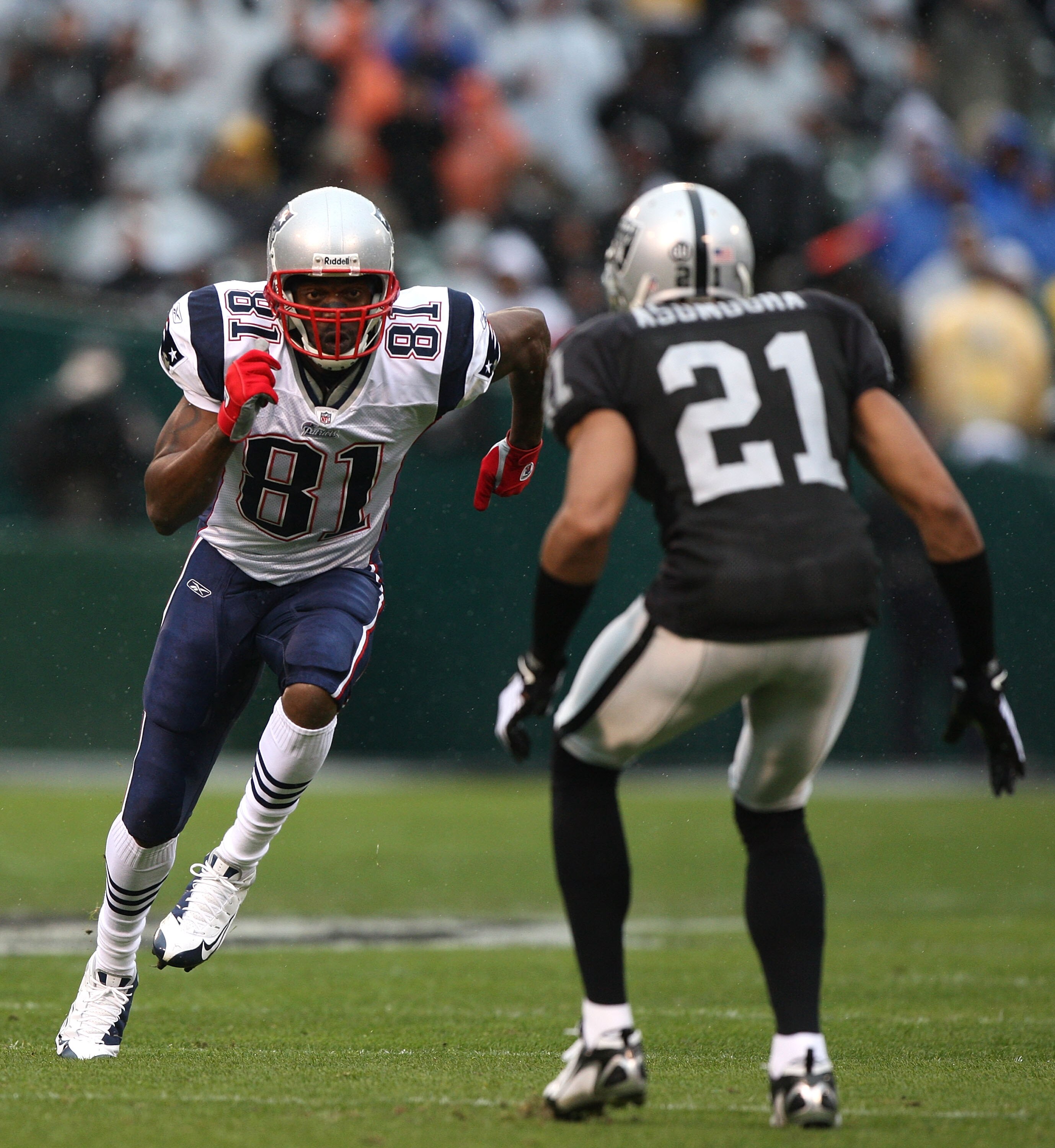 OAKLAND, CA - DECEMBER 14:  Randy Moss #81 of the New England Patriots runs against Nnamdi Asomugha #21 of the Oakland Raiders during an NFL game on December 14, 2008 at the Oakland-Alameda County Coliseum in Oakland, California.  (Photo by Jed Jacobsohn/