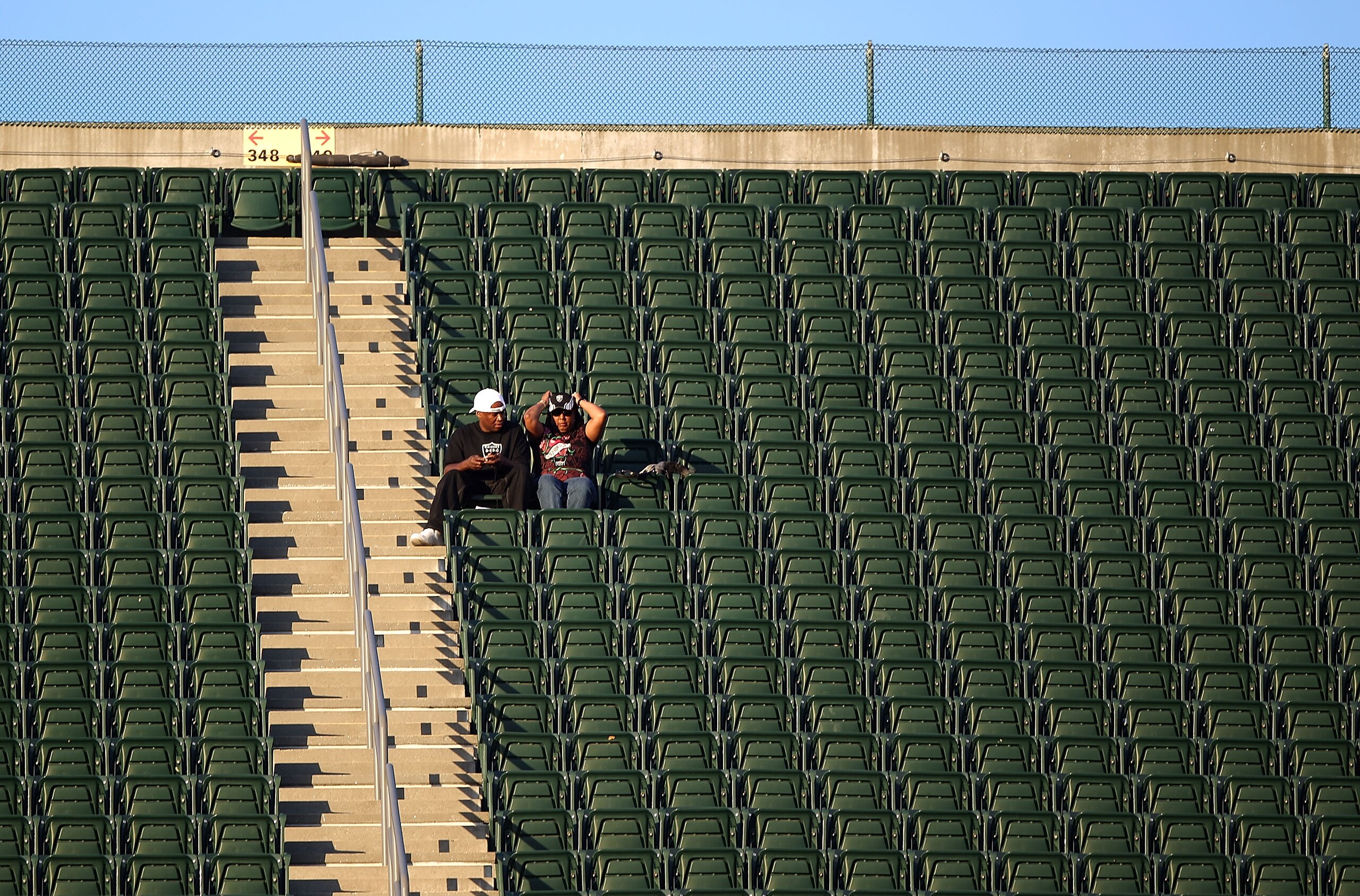 OAKLAND, CA - SEPTEMBER 02:  Two fans watch the Seattle Seahawks and the Oakland Raiders NFL preseason game at Oakland-Alameda County Coliseum on September 2, 2010 in Oakland, California.  (Photo by Jed Jacobsohn/Getty Images)