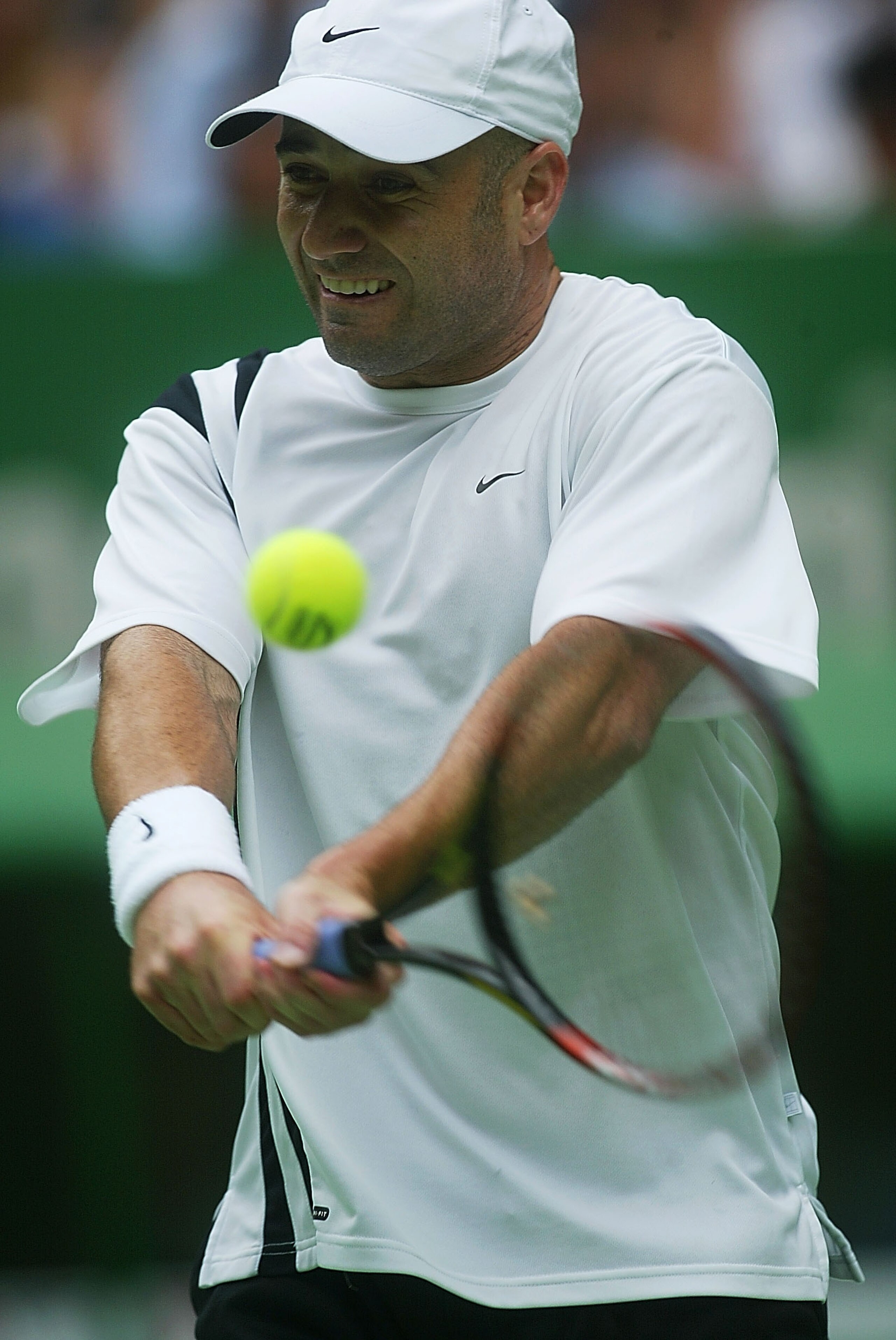 MELBOURNE - JANUARY 26:  Andre Agassi of the USA in action against Rainer Schuettler of Germany during the Australian Open Tennis Championships at Melbourne Park, Melbourne, Australia on January 26, 2003. (Photo by Sean Garnsworthy/Getty Images).