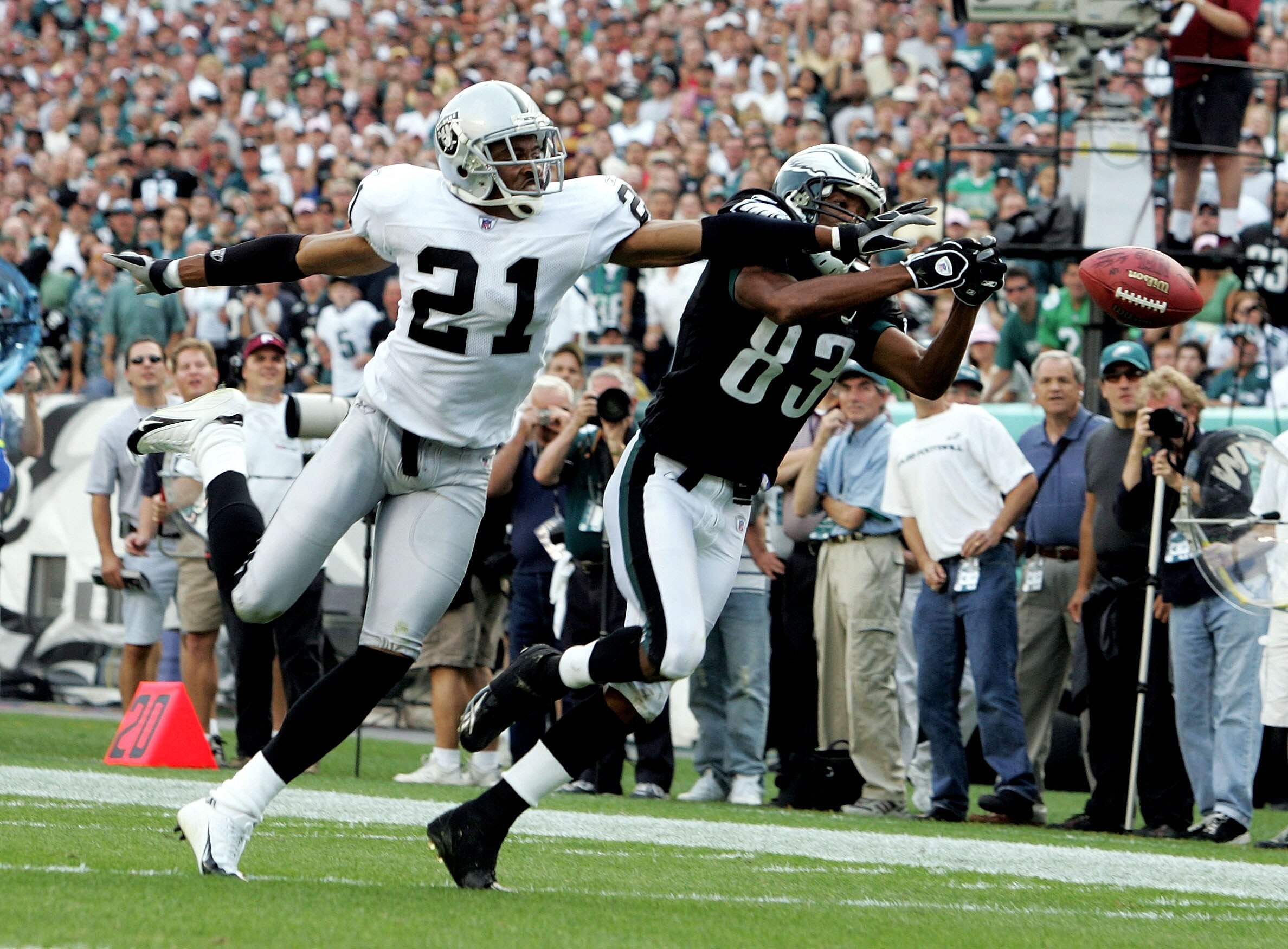 PHILADELPHIA - SEPTEMBER 25:  Wide receiver Greg Lewis #83 of the Philadelphia Eagles reaches for a pass against cornerback Nnamdi Asomugha #21 of the Oakland Raiders during their game on September 25, 2005 at Lincoln Financial Field in Philadelphia, Penn