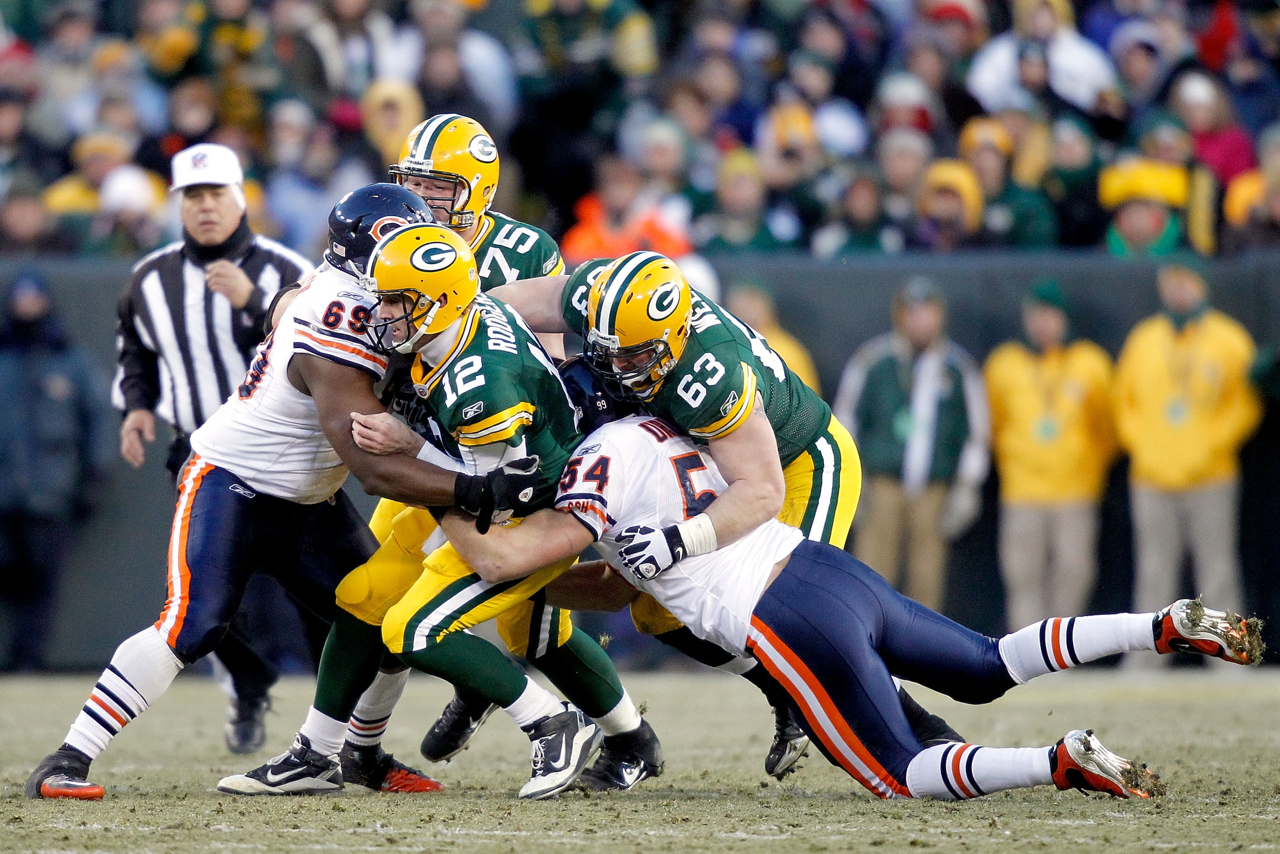 GREEN BAY, WI - JANUARY 02:  Quarterback Aaron Rodgers #12 of the Green Bay Packers is sacked by Henry Melton #69 and Brian Urlacher #54 of the Chicago Bears at Lambeau Field on January 2, 2011 in Green Bay, Wisconsin.  (Photo by Matthew Stockman/Getty Im