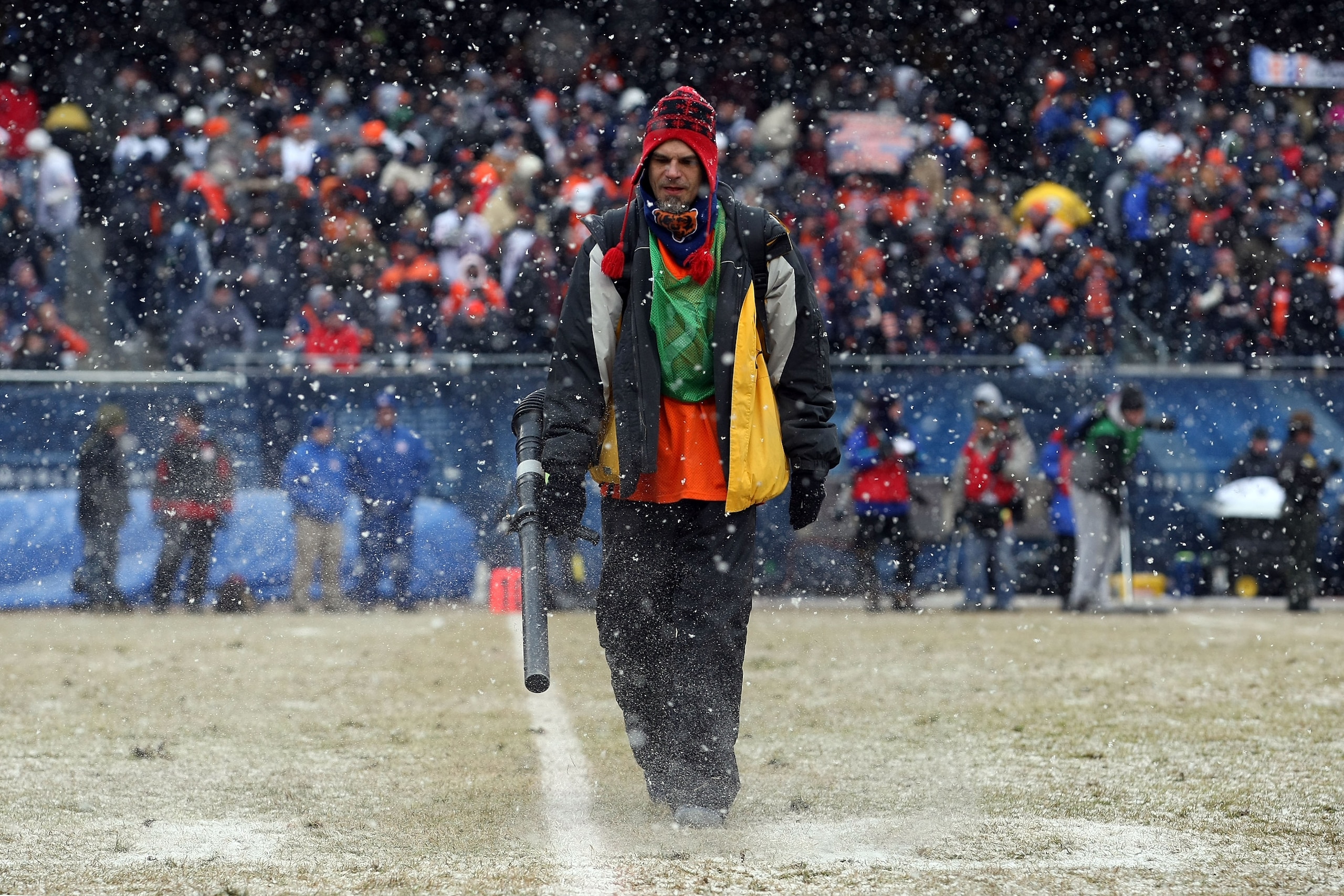 CHICAGO, IL - JANUARY 16:  A member of the field crew blows the snow off the yardage lines in the second quarter of the 2011 NFC divisional playoff game between the Seattle Seahawks and the Chicago Bears at Soldier Field on January 16, 2011 in Chicago, Il