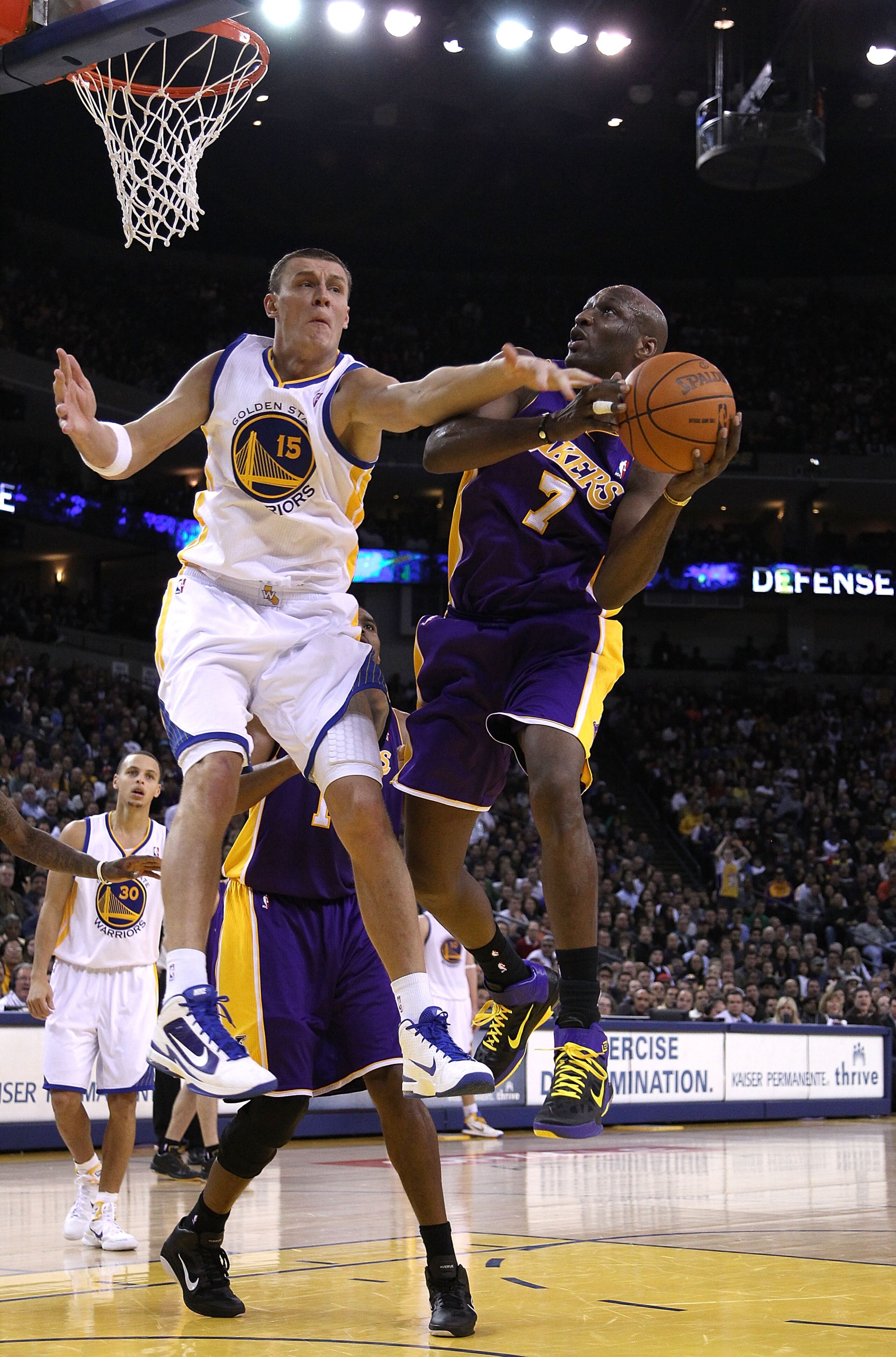 OAKLAND, CA - JANUARY 12: Lamar Odom #7 of the Los Angeles Lakers is fouled by Andris Biedrins #15 of the Golden State Warriors at Oracle Arena on January 12, 2011 in Oakland, California. NOTE TO USER: User expressly acknowledges and agrees that, by downl