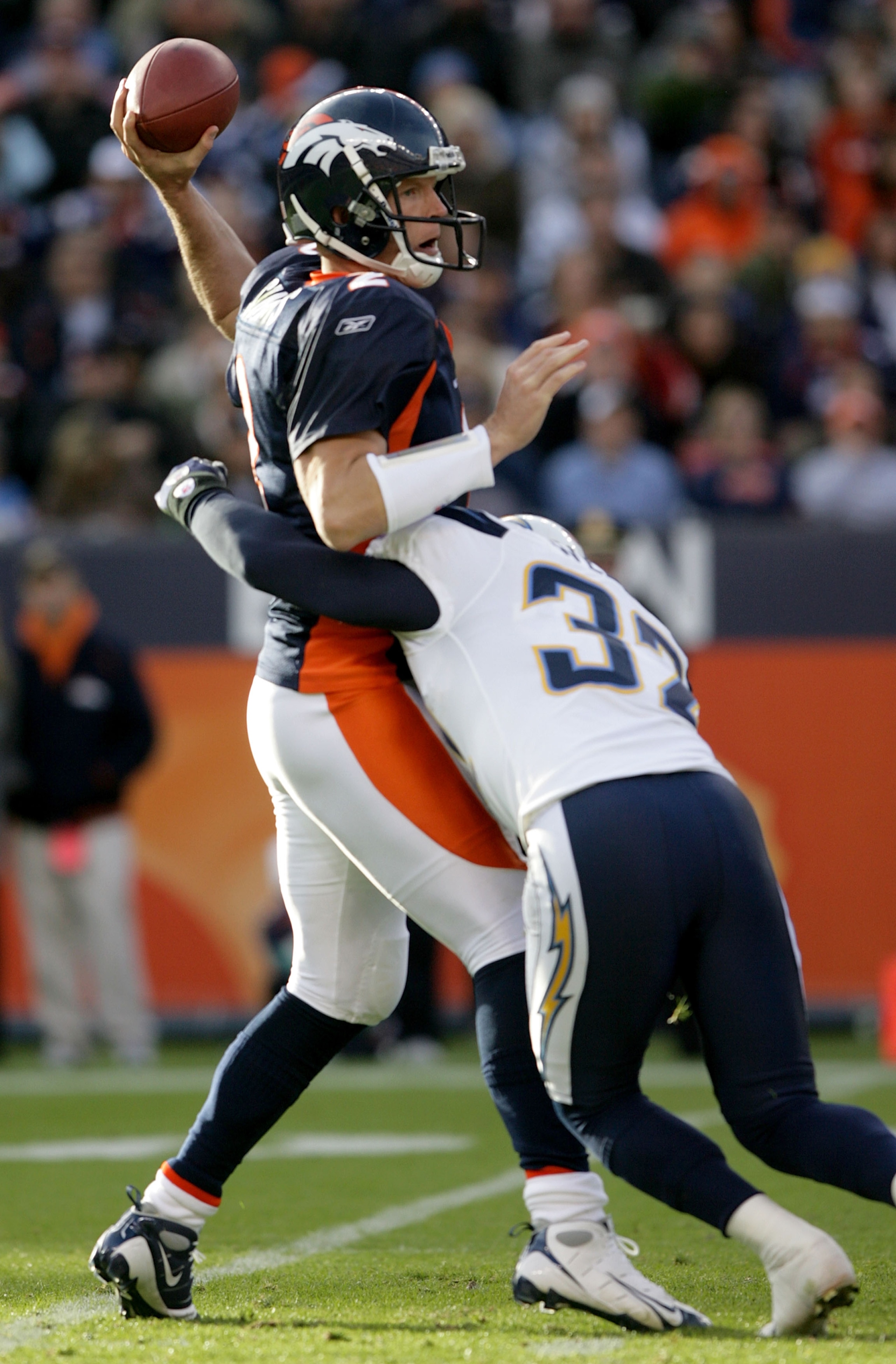 DENVER - NOVEMBER 22:  Quarterback Chris Simms #2 of the Denver Broncos is hit by Eric Weddle #32 of the San Diego Chargers as he delivers a pass during NFL action at Invesco Field at Mile High on November 22, 2009 in Denver, Colorado. The Chargers defeat