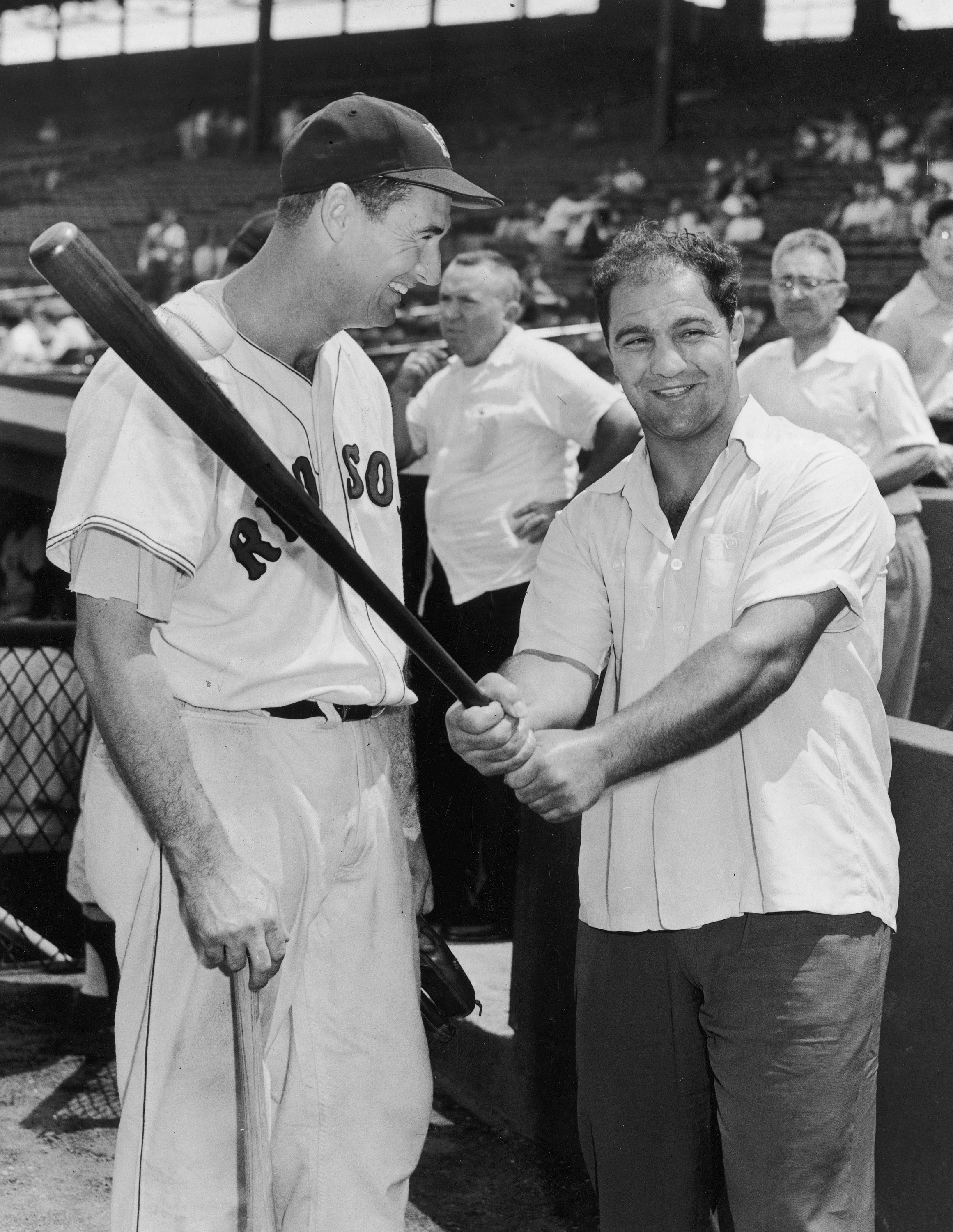 BOSTON - CIRCA 1955:  (UNDATED FILE PHOTO) Baseball legend Ted Williams (1918 - 2002) of the Boston Red Sox (L) laughs as American boxing great Rocky Marciano (1923 - 1969) swings a bat circa 1955. The 83-year-old Williams, who was the last major league p