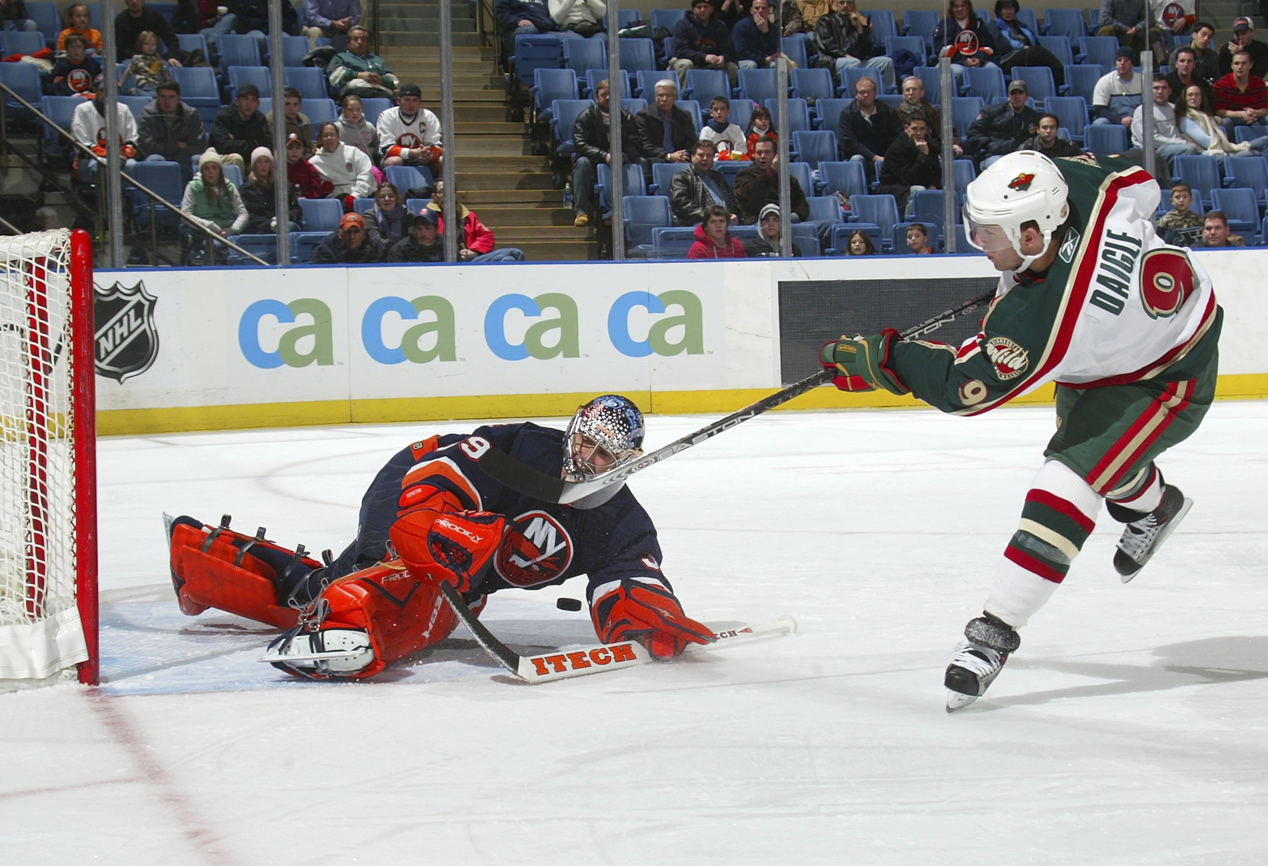 UNIONDALE, NY - DECEMBER 13:  Rick DiPietro #39 of the New York Islanders makes the save on Alexander Daigle #9 of the Minnesota Wild on December 13, 2005 at the Nassau Coliseum in Uniondale, New York. The Wild defeated the Islanders 4-3.  (Photo by Bruce