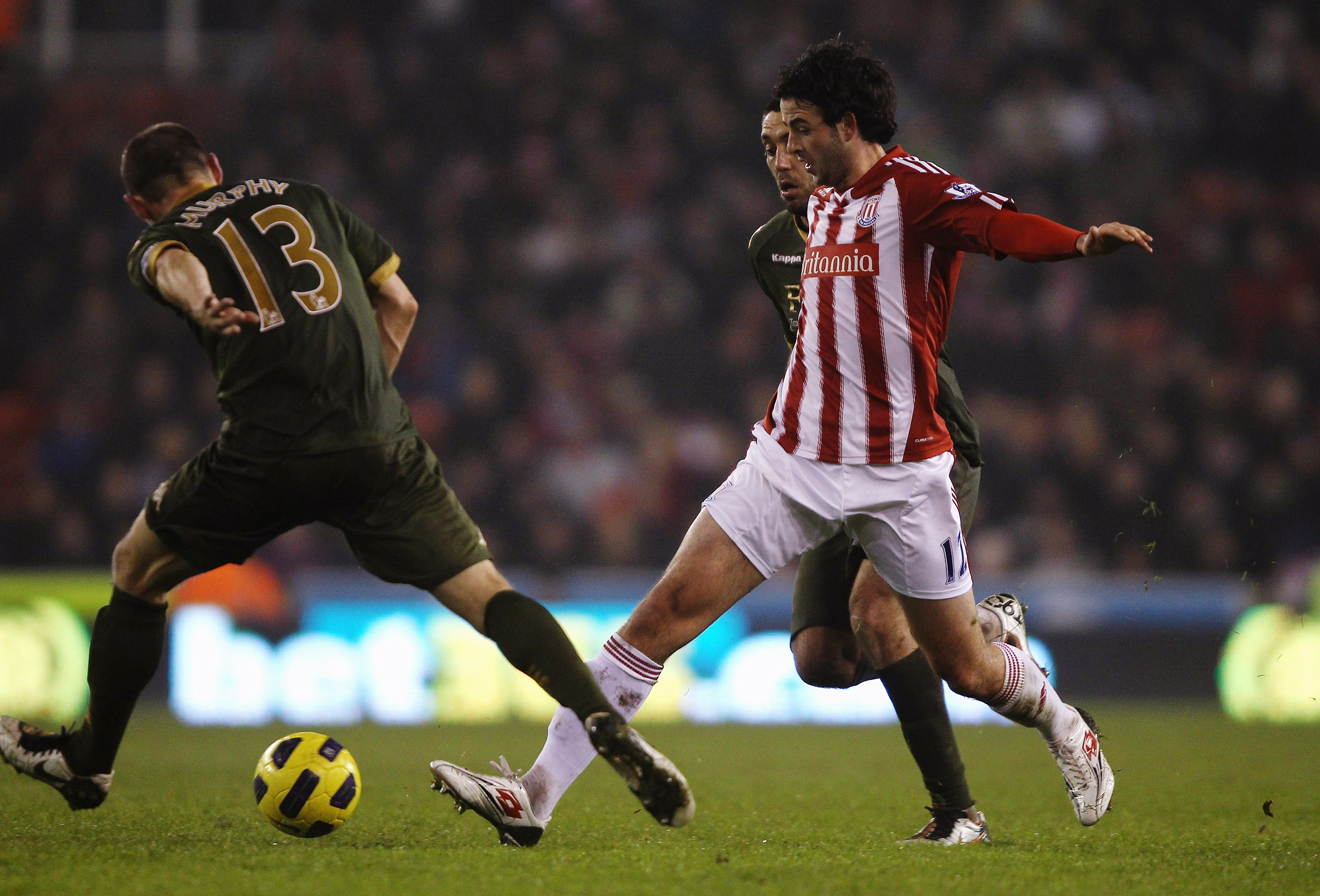 STOKE ON TRENT, ENGLAND - DECEMBER 28: Marc Wilson of Stoke City attempts to pass the ball past Danny Murphy of Fulham during the Barclays Premier League match between Stoke City and Fulham at Britannia Stadium on December 28, 2010 in Stoke on Trent, Engl