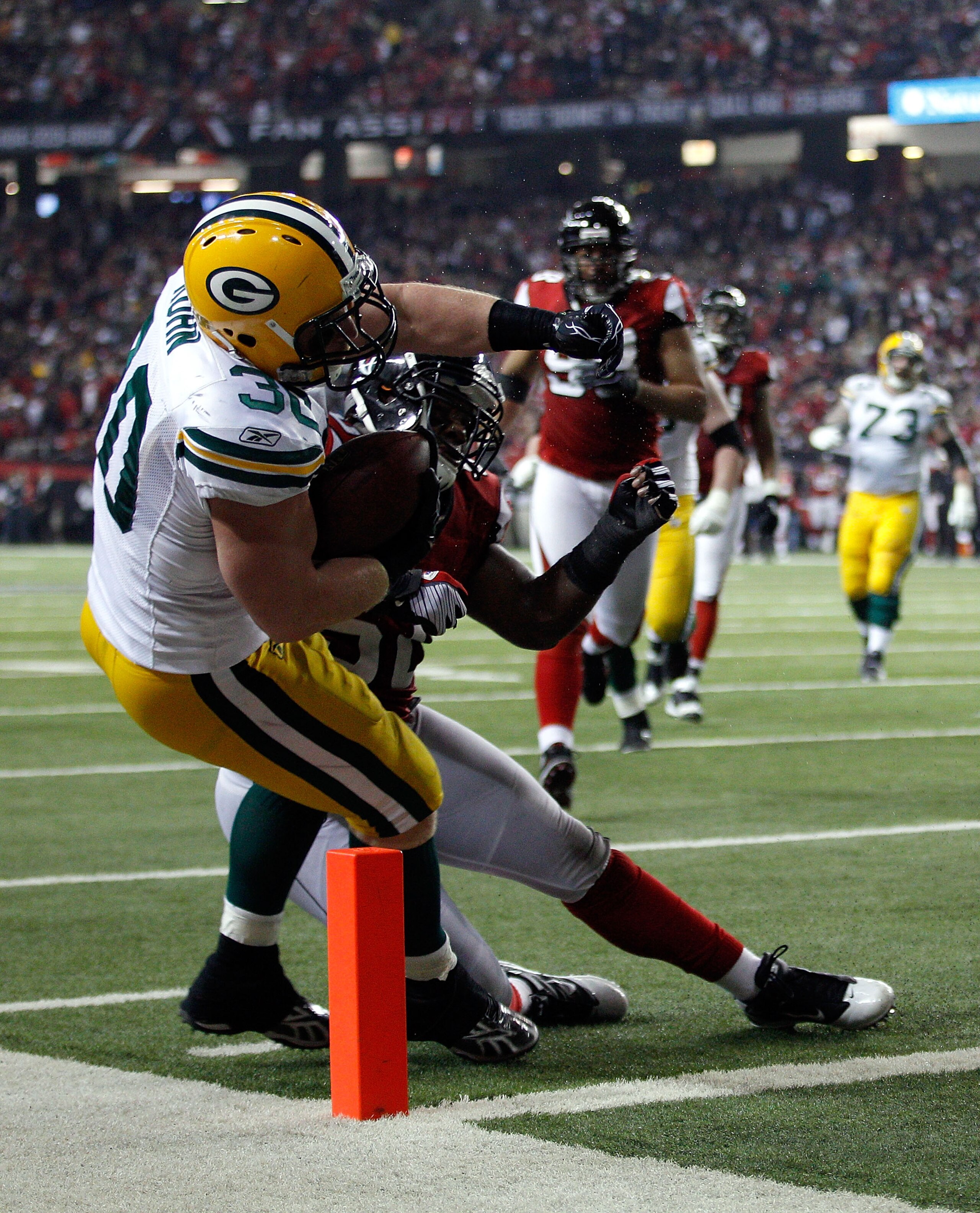 ATLANTA, GA - JANUARY 15:  John Kuhn #30 of the Green Bay Packers scores a 7-yard touchdown reception against the Atlanta Falcons during their 2011 NFC divisional playoff game at Georgia Dome on January 15, 2011 in Atlanta, Georgia.  (Photo by Chris Grayt