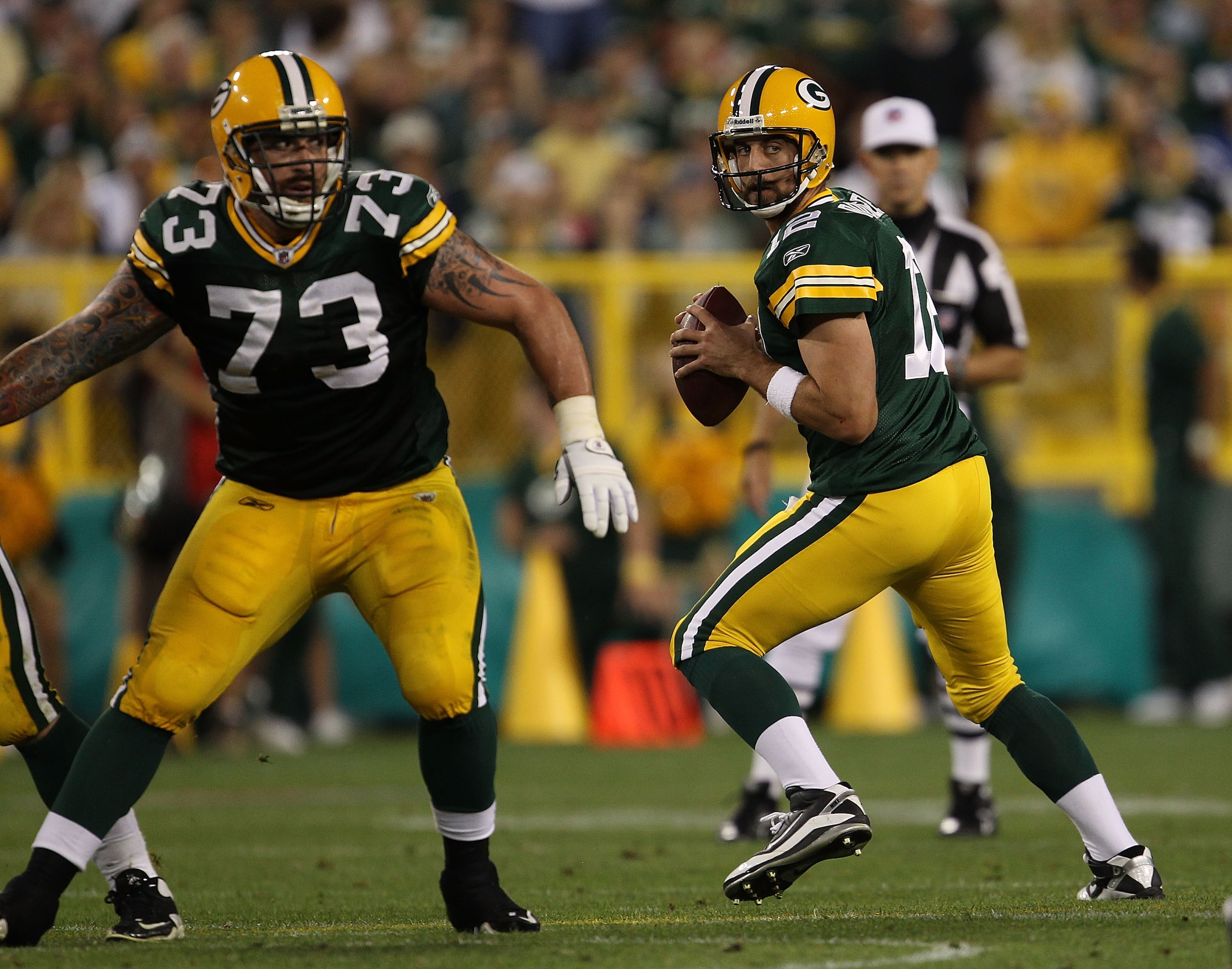 GREEN BAY, WI - AUGUST 26: Aaron Rodgers #12 of the Green Bay Packers looks for a receiver as teammate Daryn Colledge #73 looks to block against the Indianapolis Colts during a preseason game at Lambeau Field on August 26, 2010 in Green Bay, Wisconsin. Th