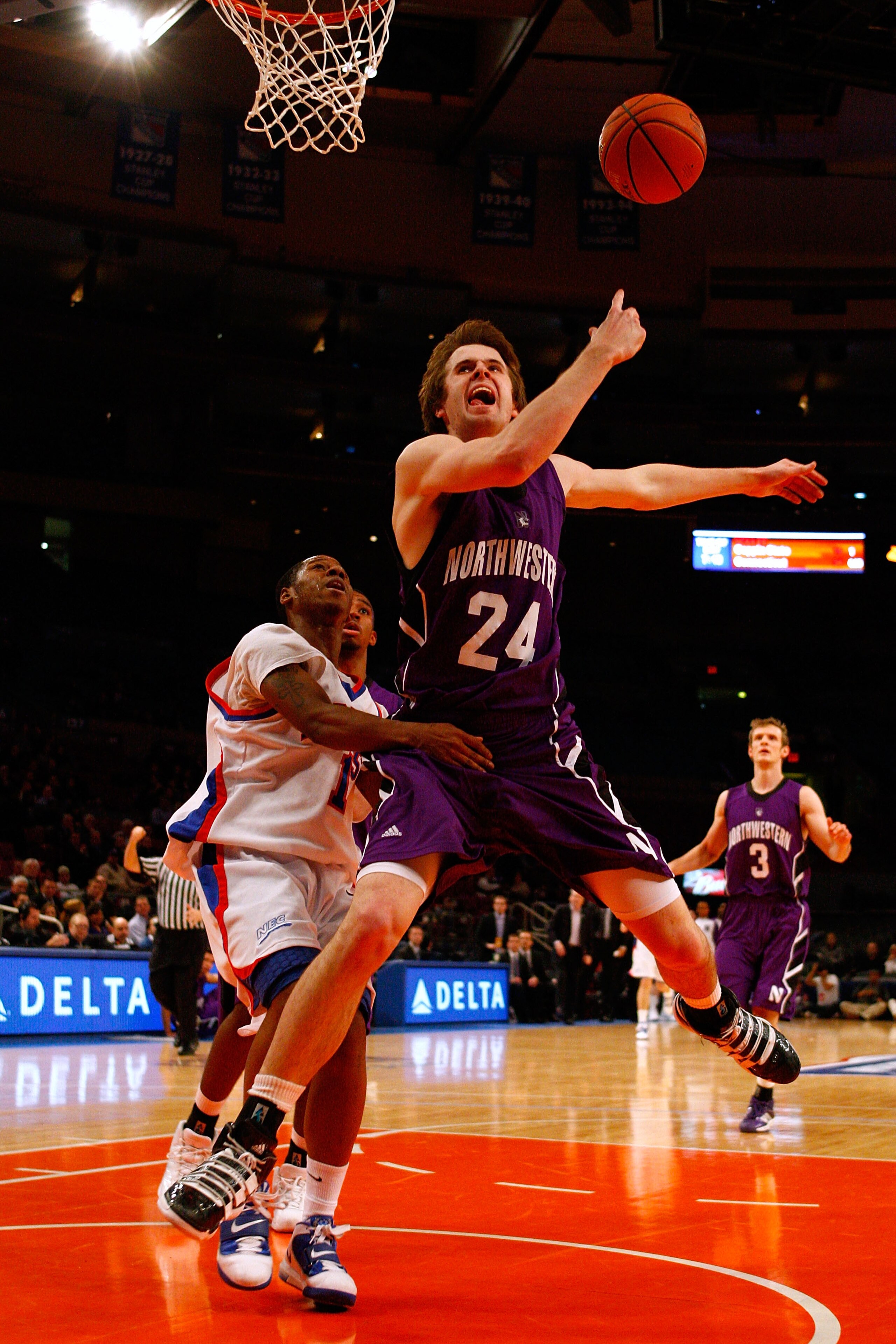 NEW YORK, NY - DECEMBER 20:  John Shurna #24 of the Northwestern Wildcats loses the ball as he is fouled on a shot attempt by Dre Calloway #1 of the St. Francis Terriers during the Madison Square Garden Holiday Festival at Madison Square Garden on Decembe
