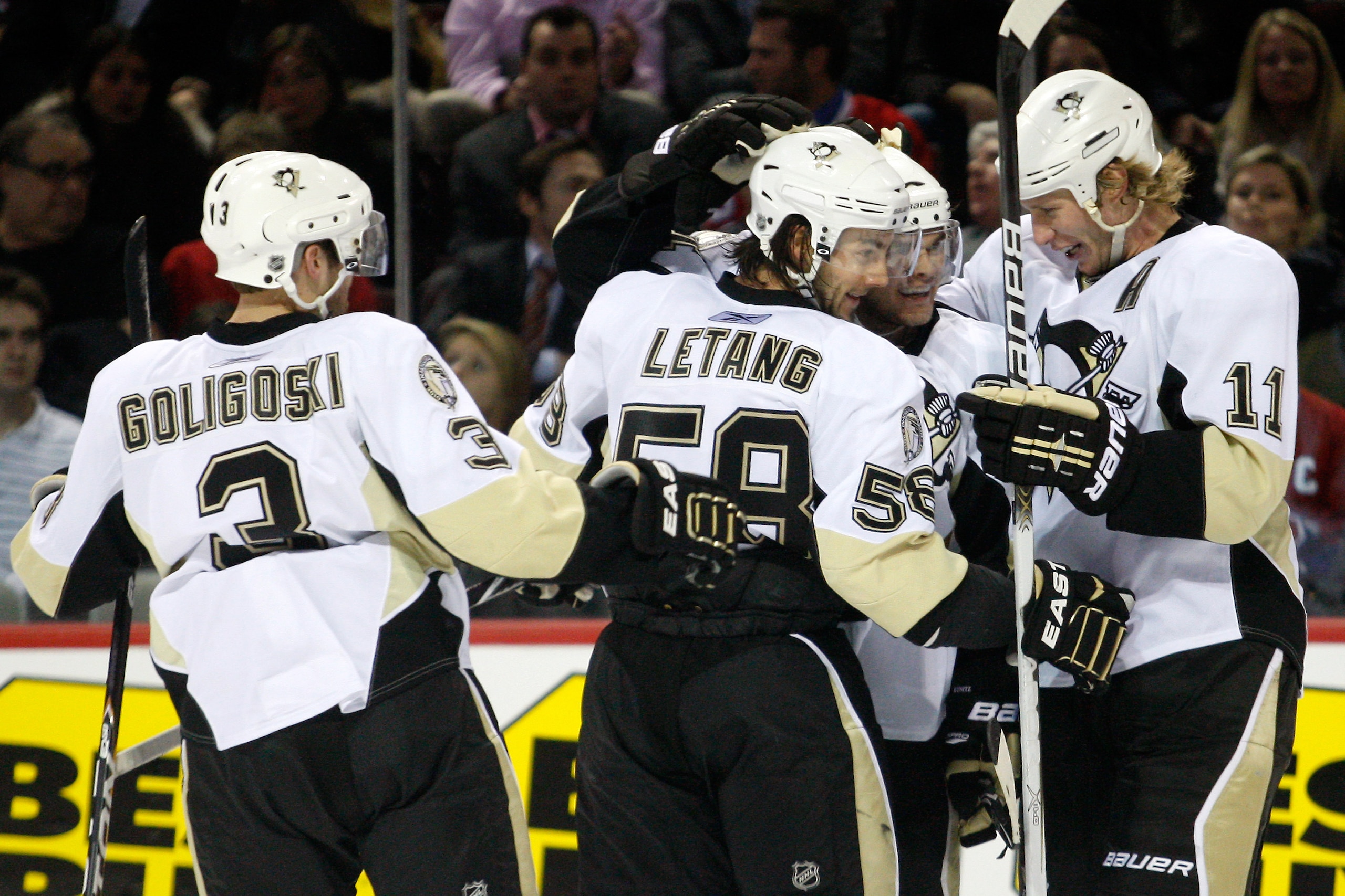 MONTREAL, CANADA - JANUARY 12:  Chris Kunitz #14 of the Pittsburgh Penguins celebrates his third period goal with team mates (L-R) Alex Goligoski #3, Kris Letang #58 and Jordan Staal #11 during the NHL game against the Montreal Canadiens at the Bell Centr