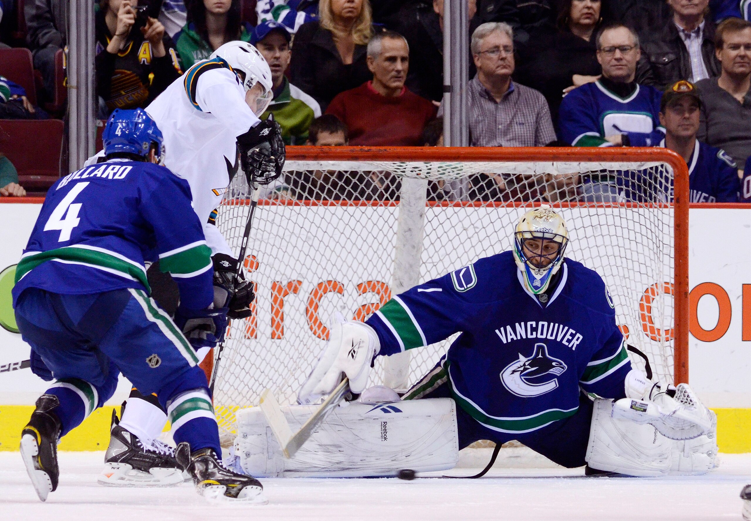 VANCOUVER, CANADA - JANUARY 20: Goalie Roberto Luongo #1 of the Vancouver Canucks slides across his crease to stop Dany Heatley #15 of the San Jose Sharks while Keith Ballard #4 of the Canucks try to help defend during the second period in NHL action on J VANCOUVER, CANADA - JANUARY 20: Goalie Roberto Luongo #1 of the Vancouver Canucks slides across his crease to stop Dany Heatley #15 of the San Jose Sharks while Keith Ballard #4 of the Canucks try to help defend during the second period in NHL action on J