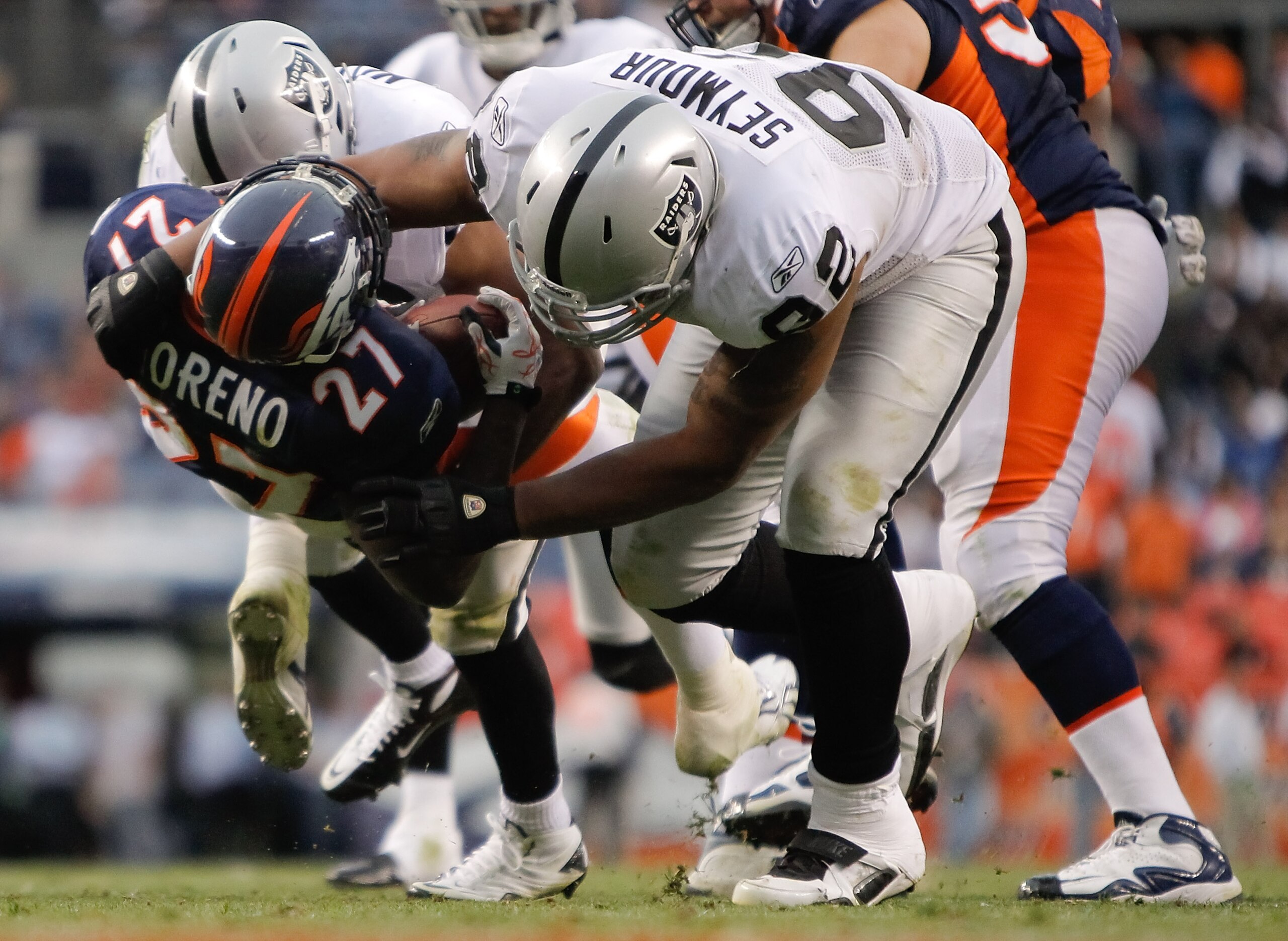 DENVER - OCTOBER 24:  Defensive end Richard Seymour #92 of the Oakland Raiders throws running back Knowshon Moreno #27 of the Denver Broncos to the ground in the fourth quarter at INVESCO Field at Mile High on October 24, 2010 in Denver, Colorado. The Rai