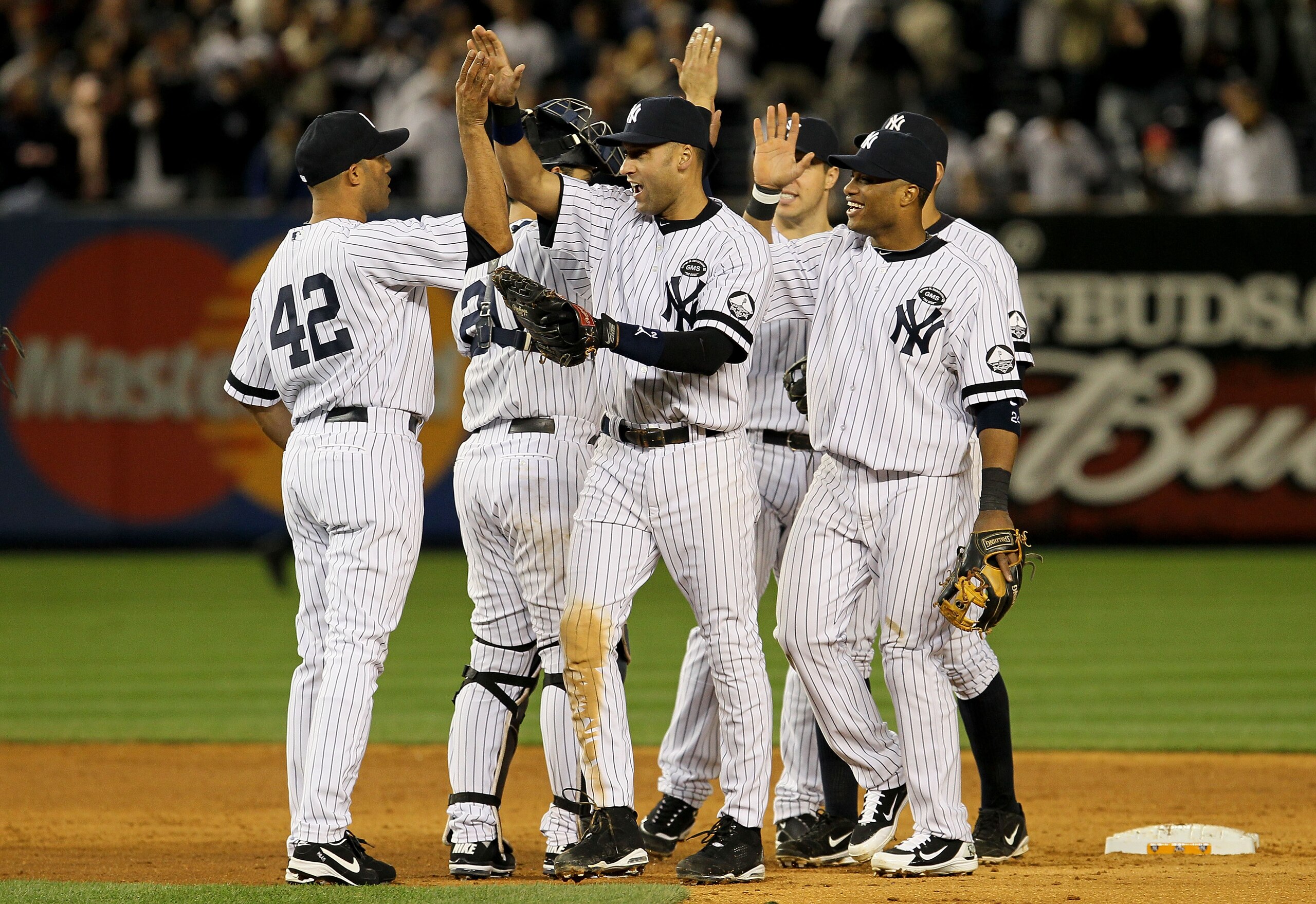 NEW YORK - OCTOBER 09:  (L-R) Mariano Rivera #42, Derek Jeter #2 and Robinson Cano #24 of the New York Yankees celebrate after their 6-1 win against the Minnesota Twins during Game Three of the ALDS part of the 2010 MLB Playoffs at Yankee Stadium on Octob