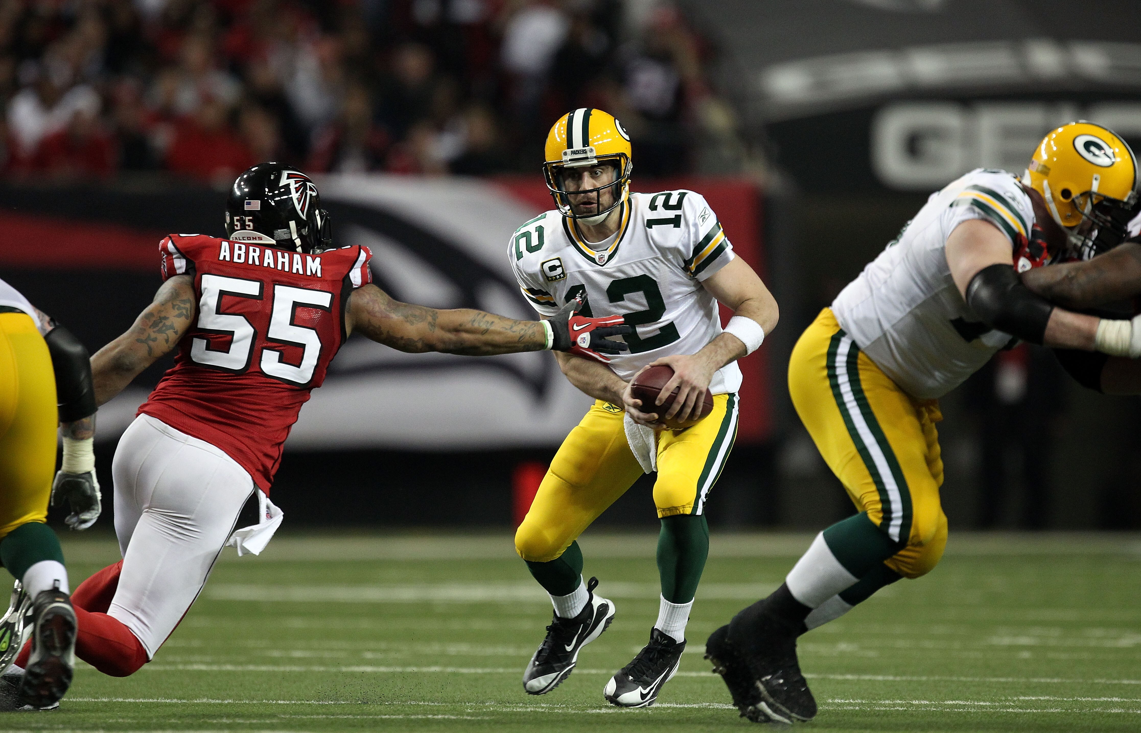 ATLANTA, GA - JANUARY 15:  Aaron Rodgers #12 of the Green Bay Packers elludes the pass rush of John Abraham #55 of the Atlanta Falcons during their 2011 NFC divisional playoff game at Georgia Dome on January 15, 2011 in Atlanta, Georgia.  (Photo by Street