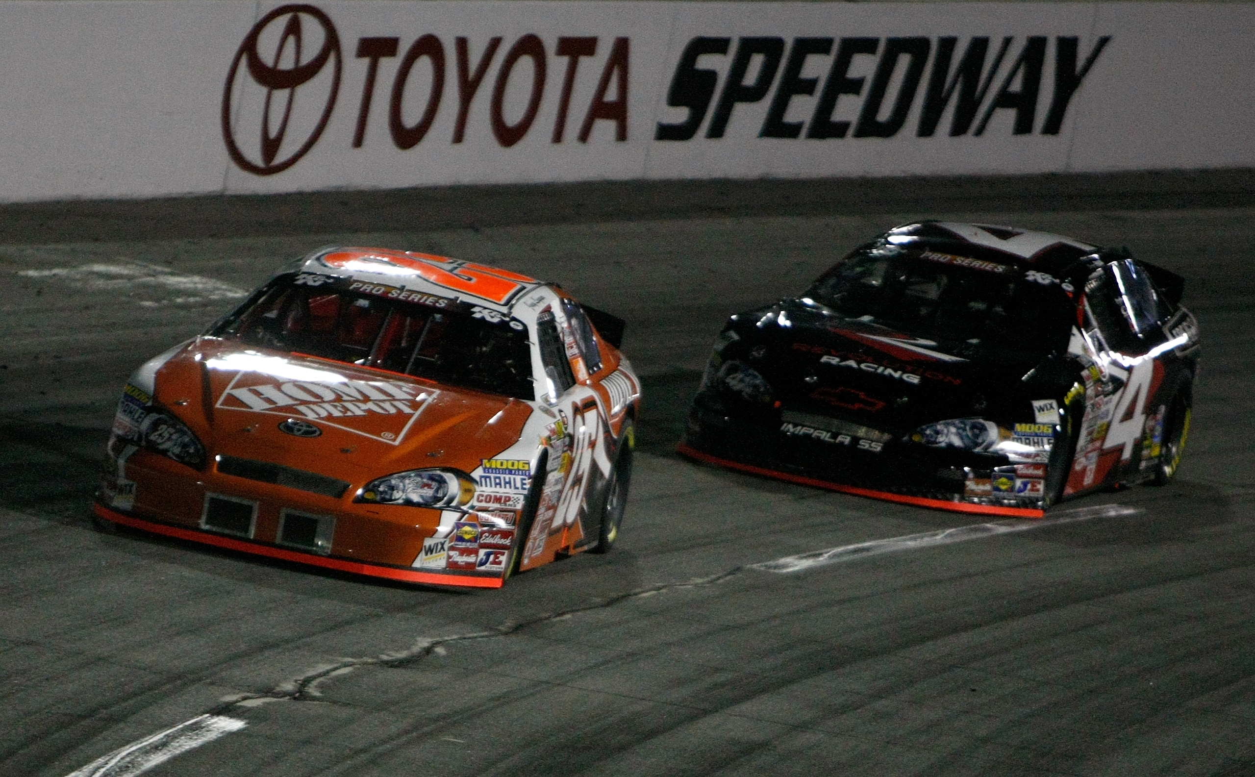 IRWINDALE, CA - JANUARY 30:  Joey Logano driver of the #25 Home Depot Toyota battles Sergio Pena in the #4 Revolution Racing Chevrolet during  the NASCAR Toyota All-Star Showdow at Toyota Speedway  on January 30, 2010 in Irwindale, California.  (Photo by