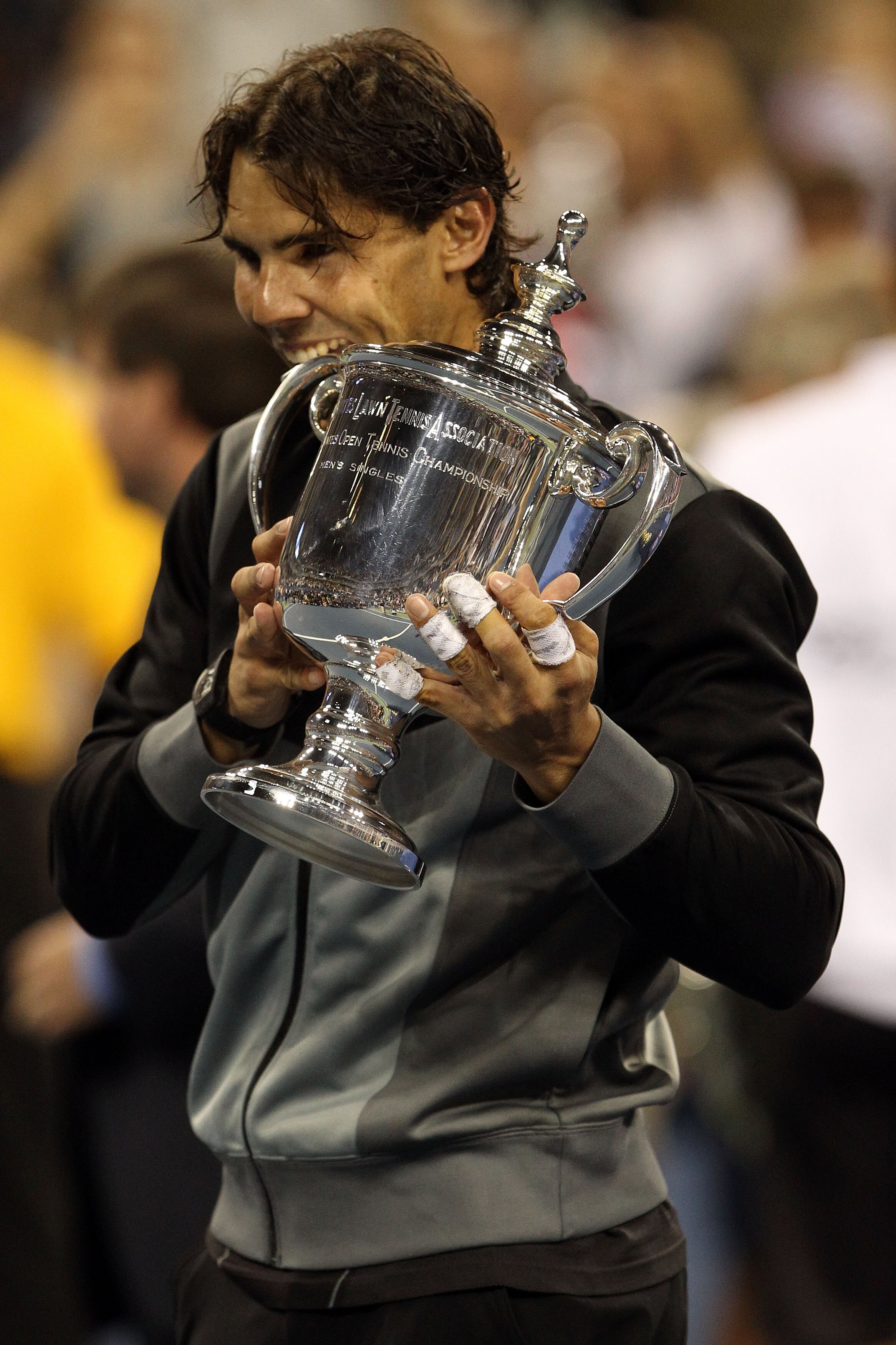 NEW YORK - SEPTEMBER 13:  Rafael Nadal of Spain bites the championship trophy after defeating Novak Djokovic of Serbia to win the men's singles final on day fifteen of the 2010 U.S. Open at the USTA Billie Jean King National Tennis Center on September 13,