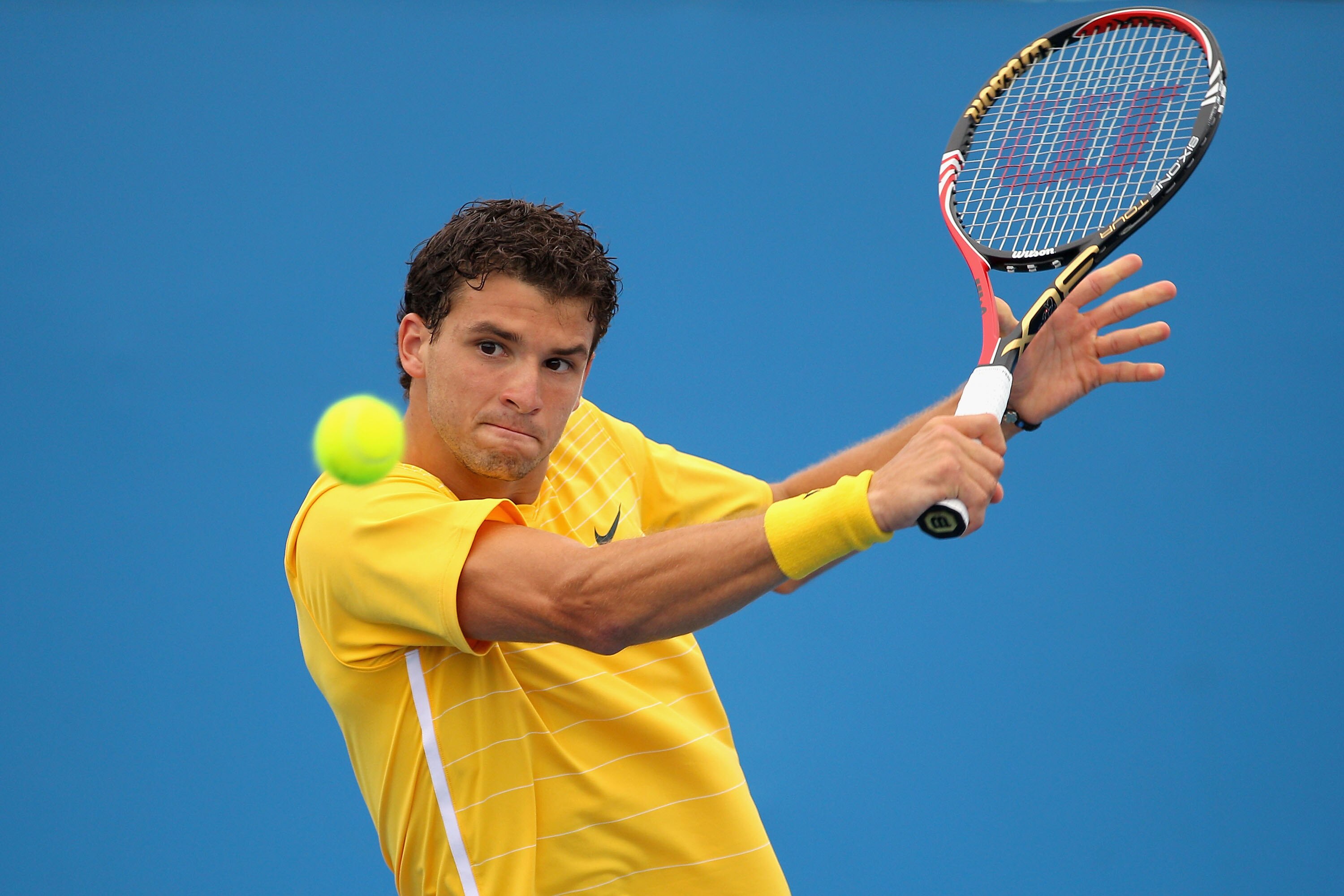 MELBOURNE, AUSTRALIA - JANUARY 17:  Grigor Dimitrov of Bulgaria plays a backhand in his first round match against Andrey Golubev of Kazakhstan during day one of the 2011 Australian Open at Melbourne Park on January 17, 2011 in Melbourne, Australia.  (Phot