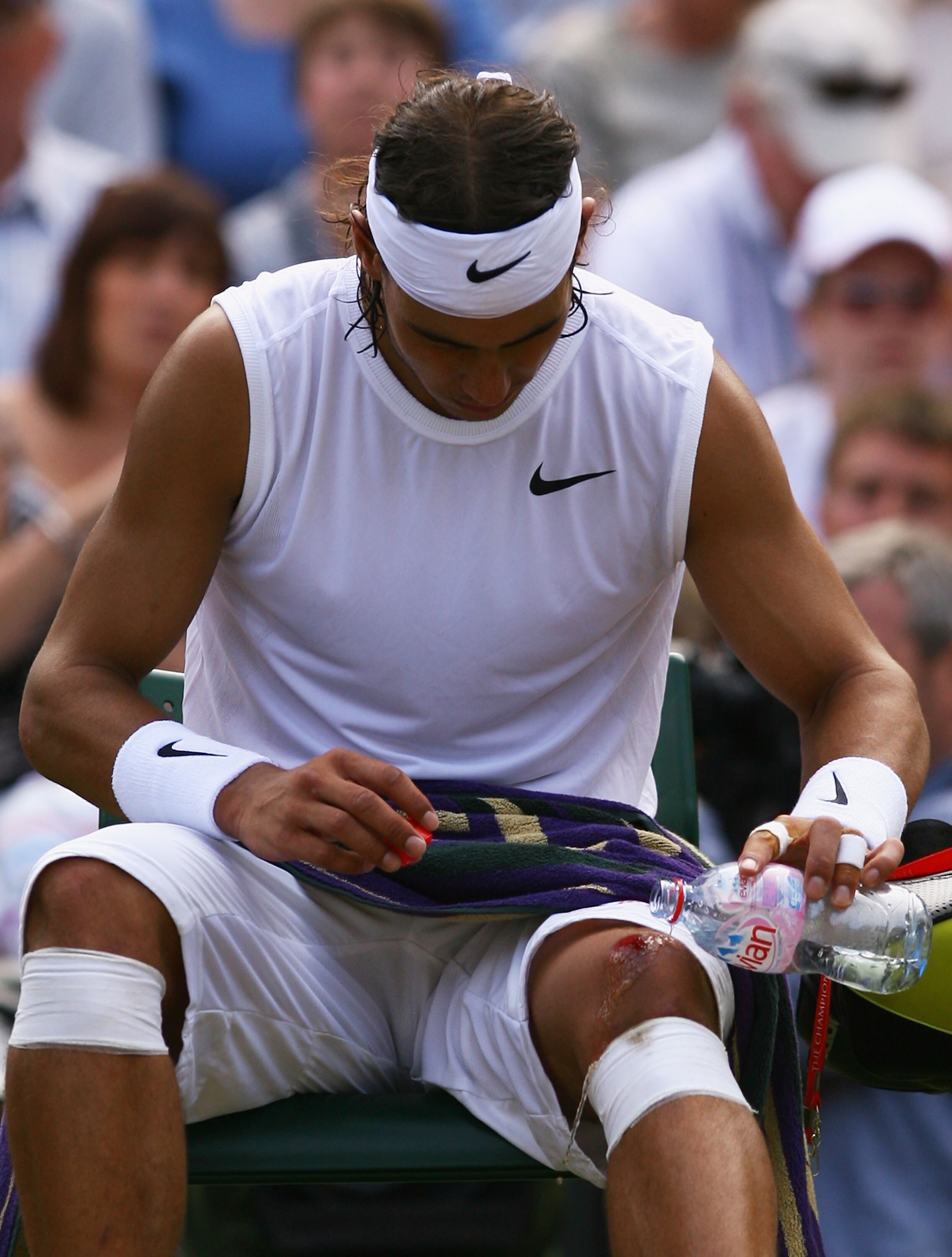 LONDON - JULY 04:  Rafael Nadal of Spain washes his cut knee with water during the men's singles Semi Final match against Rainer Schuettler of Germany on day eleven of the Wimbledon Lawn Tennis Championships at the All England Lawn Tennis and Croquet Club