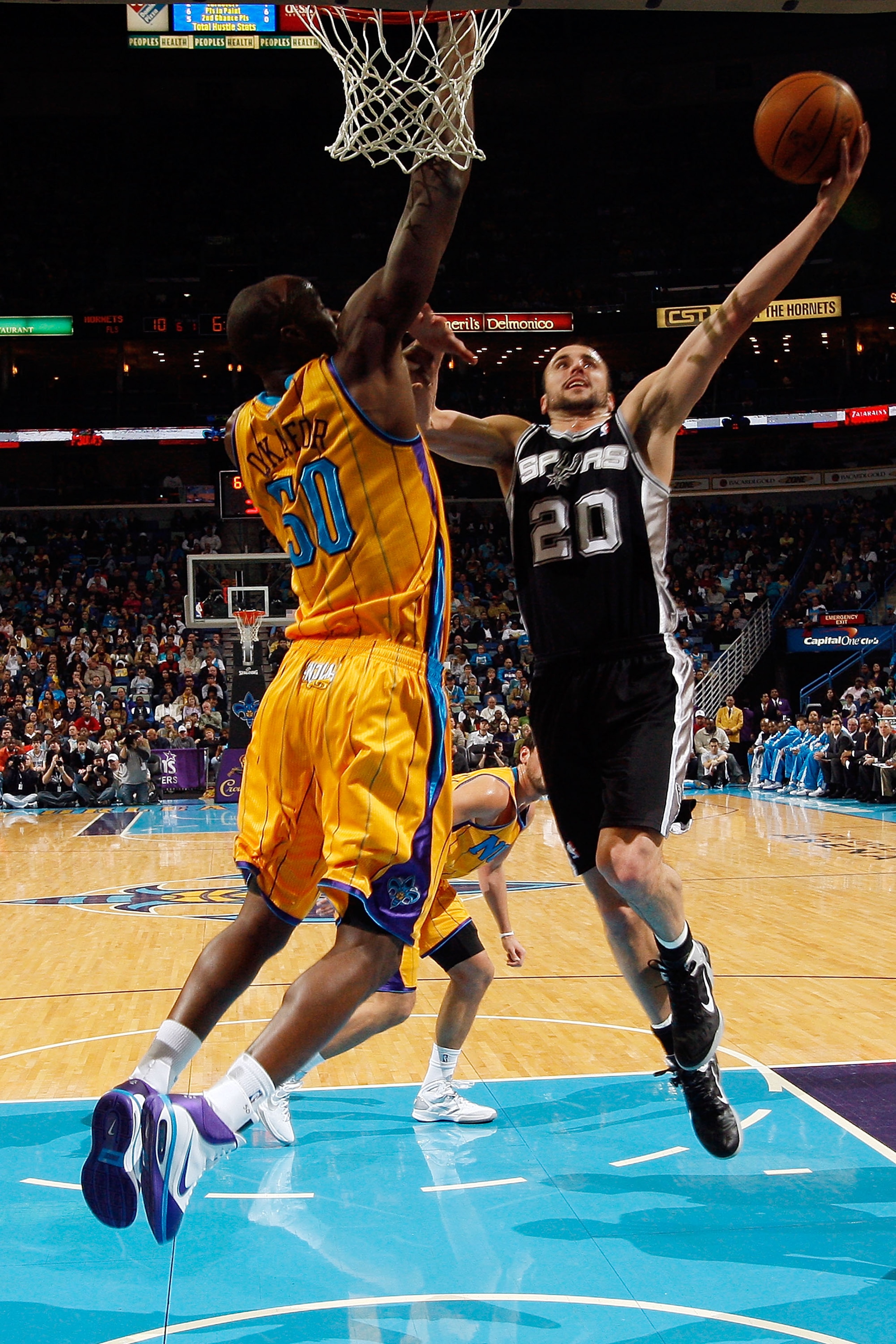 NEW ORLEANS, LA - JANUARY 22:  Manu Ginobili #20 of the San Antonio Spurs shoots the ball over Emeka Okafor #50 of the New Orleans Hornets at the New Orleans Arena on January 22, 2011 in New Orleans, Louisiana.  NOTE TO USER: User expressly acknowledges a