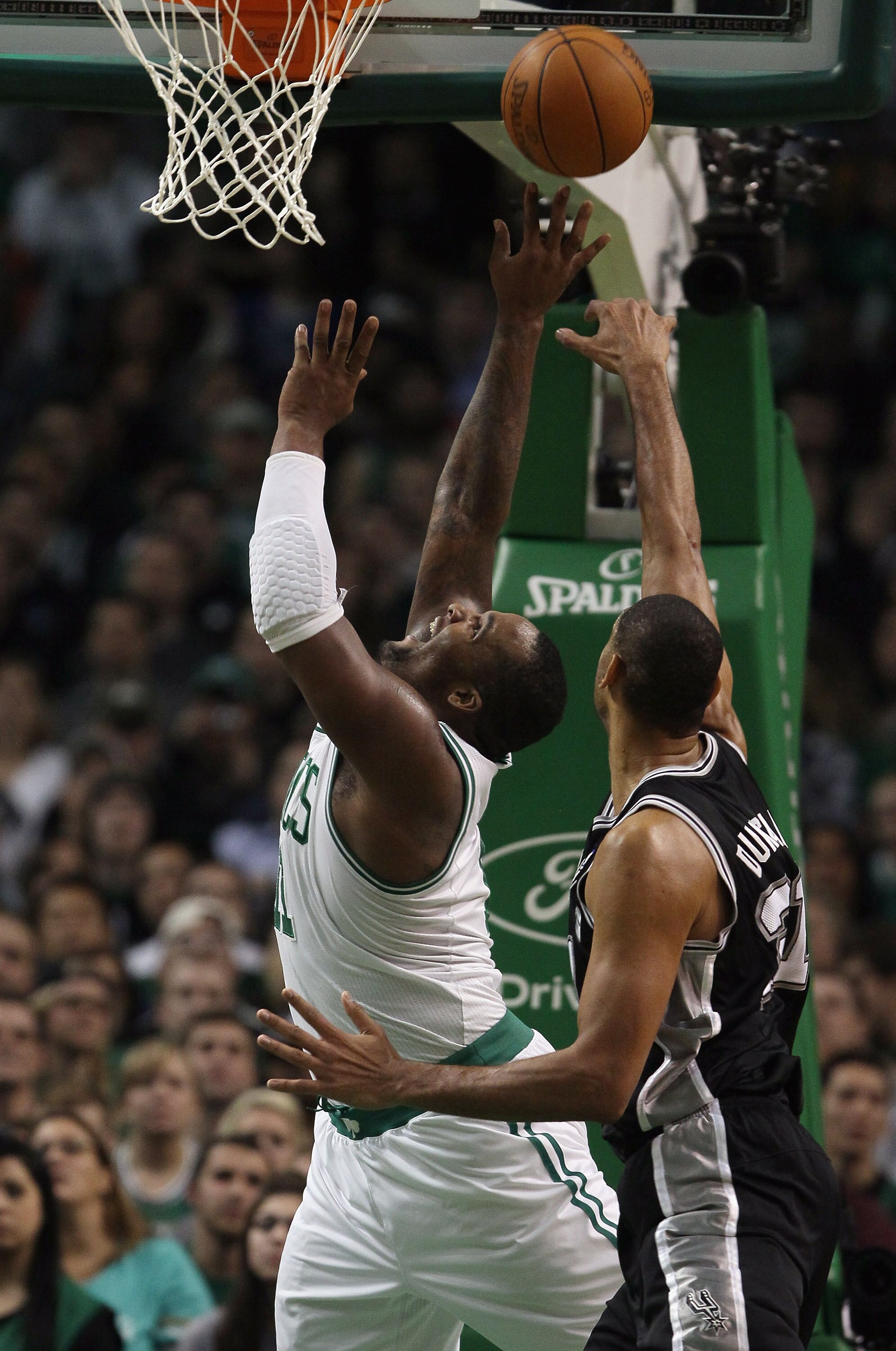 BOSTON, MA - JANUARY 05:  Glen Davis #11 of the Boston Celtics takes a shot as Tim Duncan #21 of the San Antonio Spurs defends on January 5, 2011 at the TD Garden in Boston, Massachusetts. The Celtics defeated the Spurs 105-103. NOTE TO USER: User express