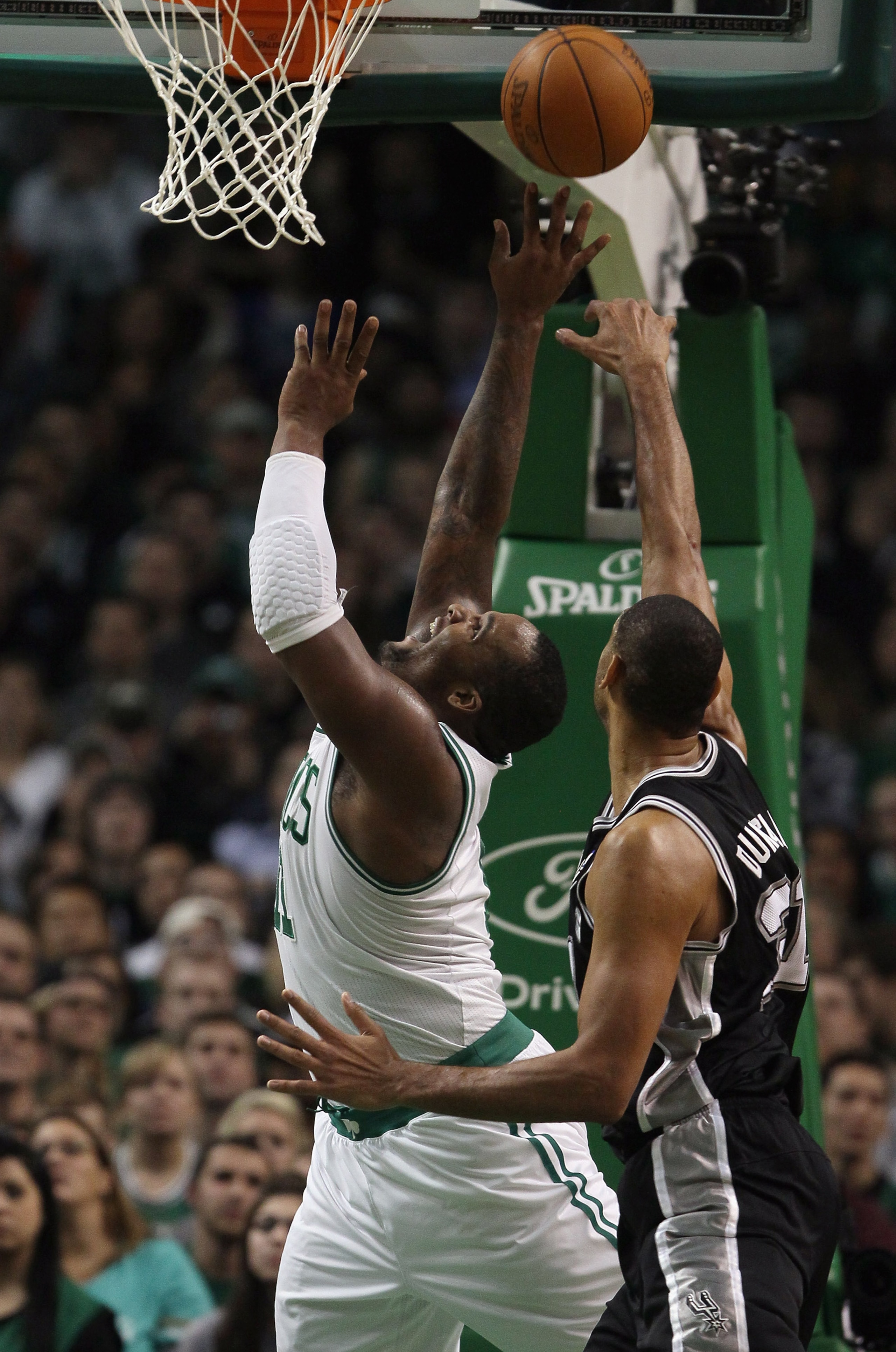 BOSTON, MA - JANUARY 05:  Glen Davis #11 of the Boston Celtics takes a shot as Tim Duncan #21 of the San Antonio Spurs defends on January 5, 2011 at the TD Garden in Boston, Massachusetts. The Celtics defeated the Spurs 105-103. NOTE TO USER: User express