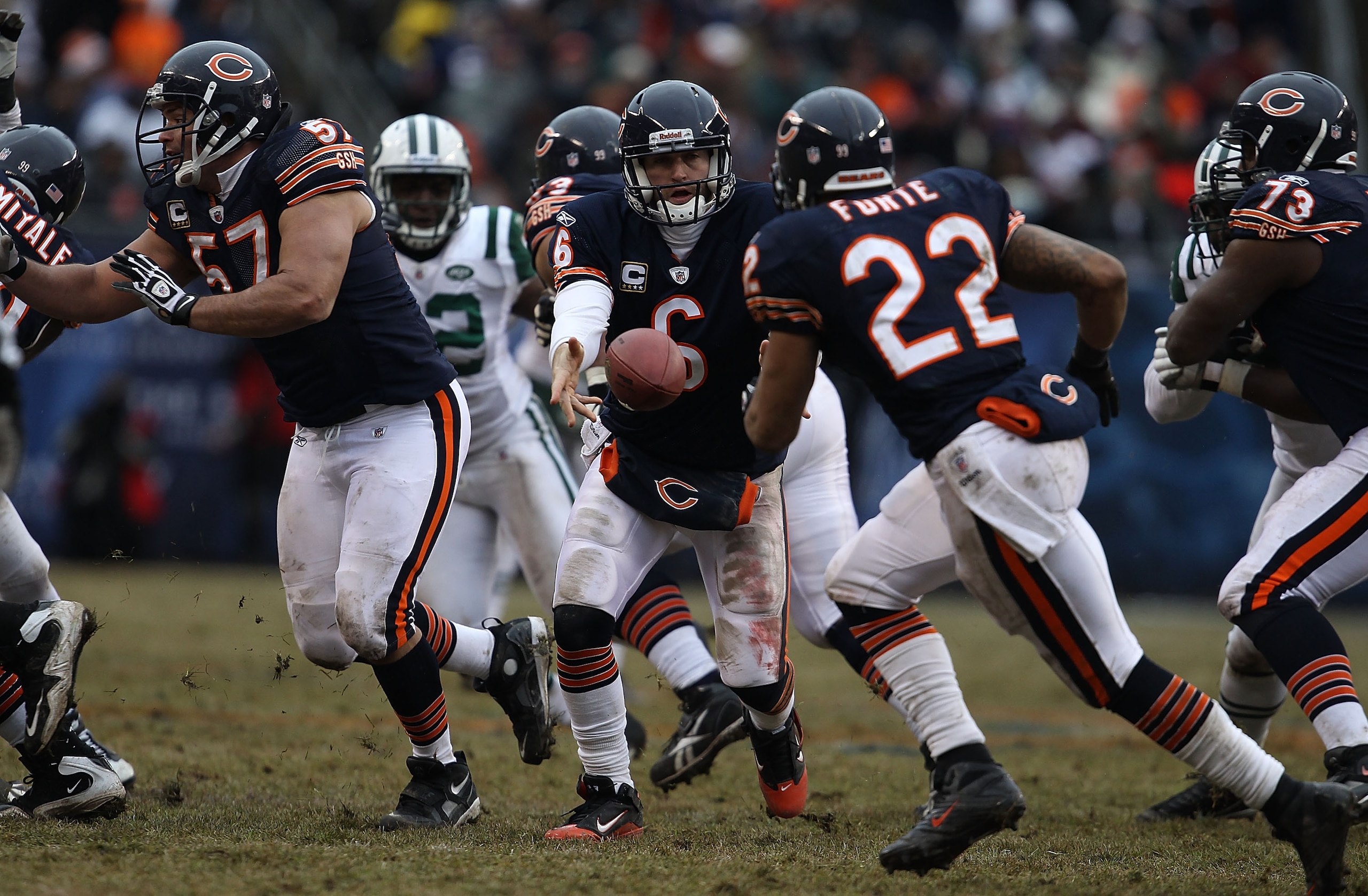 CHICAGO, IL - DECEMBER 26: Jay Cutler #6 of the Chicago Bears tosses the ball to Matt Forte #22 as teammate Olin Kreutz #57 moves to block against the New York Jets at Soldier Field on December 26, 2010 in Chicago, Illinois. The Bears defeated the Jets 38