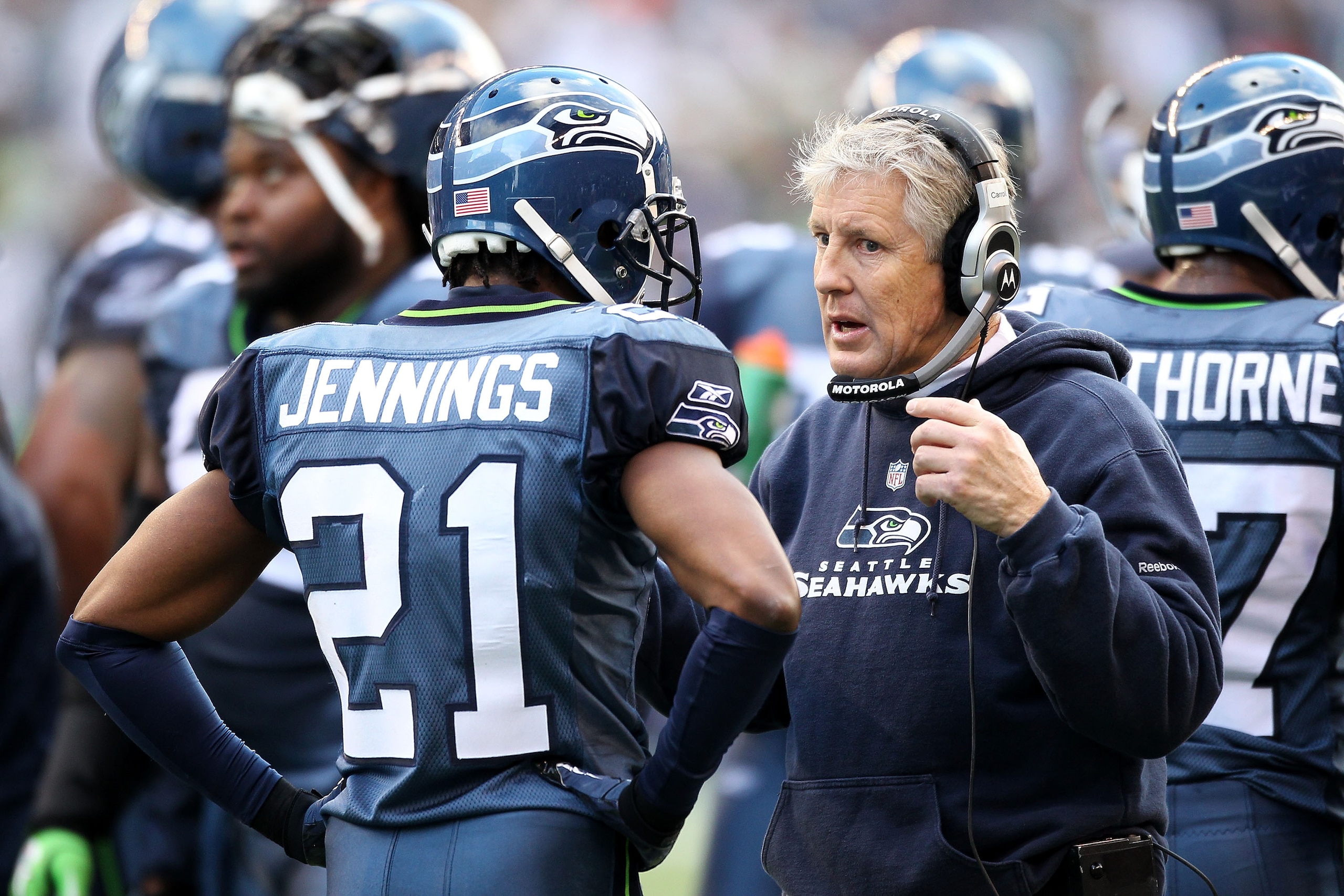SEATTLE, WA - JANUARY 08:  Head coach Pete Carroll talks with Kelly Jennings #21 of the Seattle Seahawks during their game against the New Orleans Saints during the 2011 NFC wild-card playoff game at Qwest Field on January 8, 2011 in Seattle, Washington.