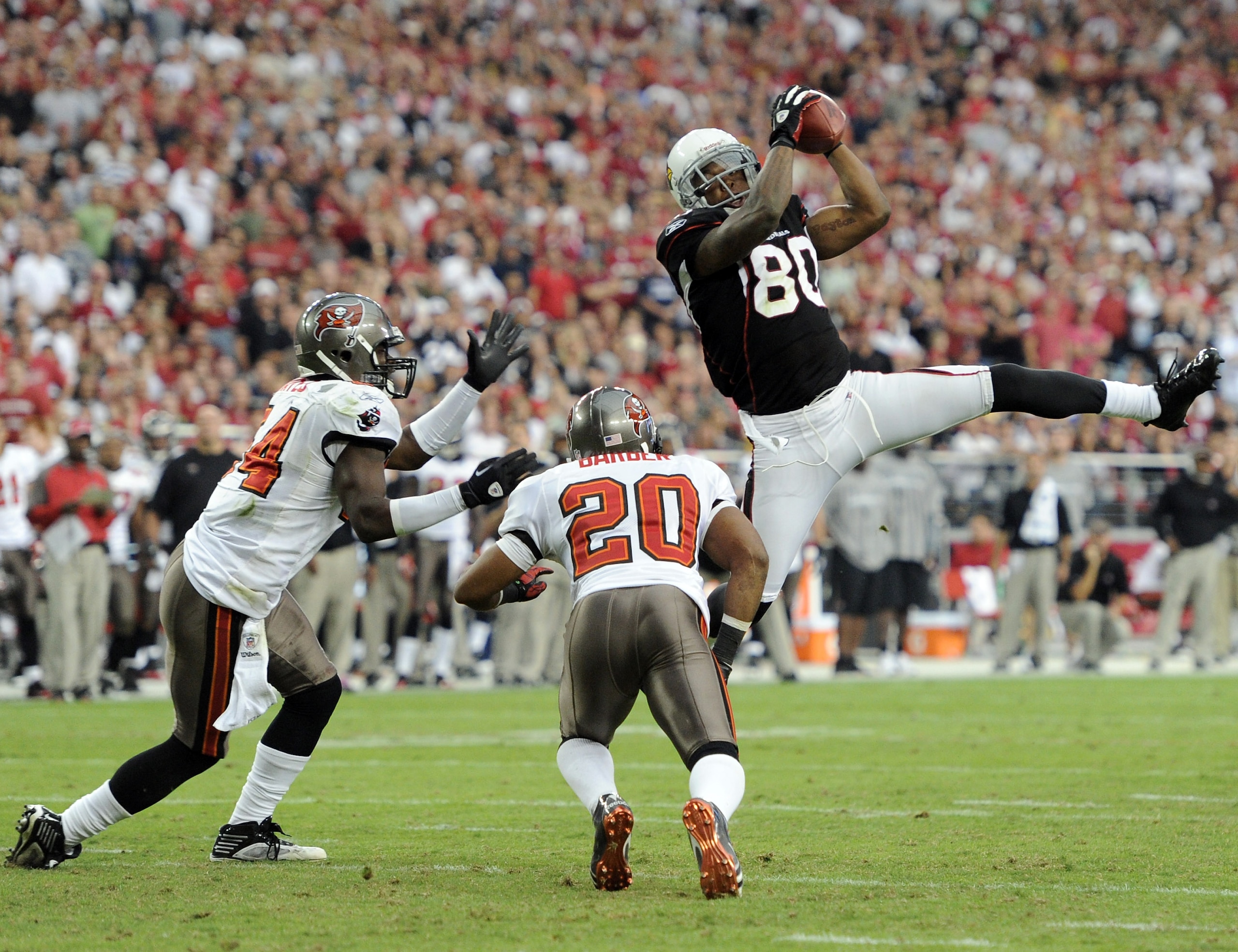 GLENDALE, AZ - OCTOBER 31:  Early Doucet #80 of the Arizona Cardinals makes a catch in front of Ronde Barber #20 and Geno Hayes #54 of the Tampa Bay Buccaneers during the fourth quarter at University of Phoenix Stadium on October 31, 2010 in Glendale, Ari