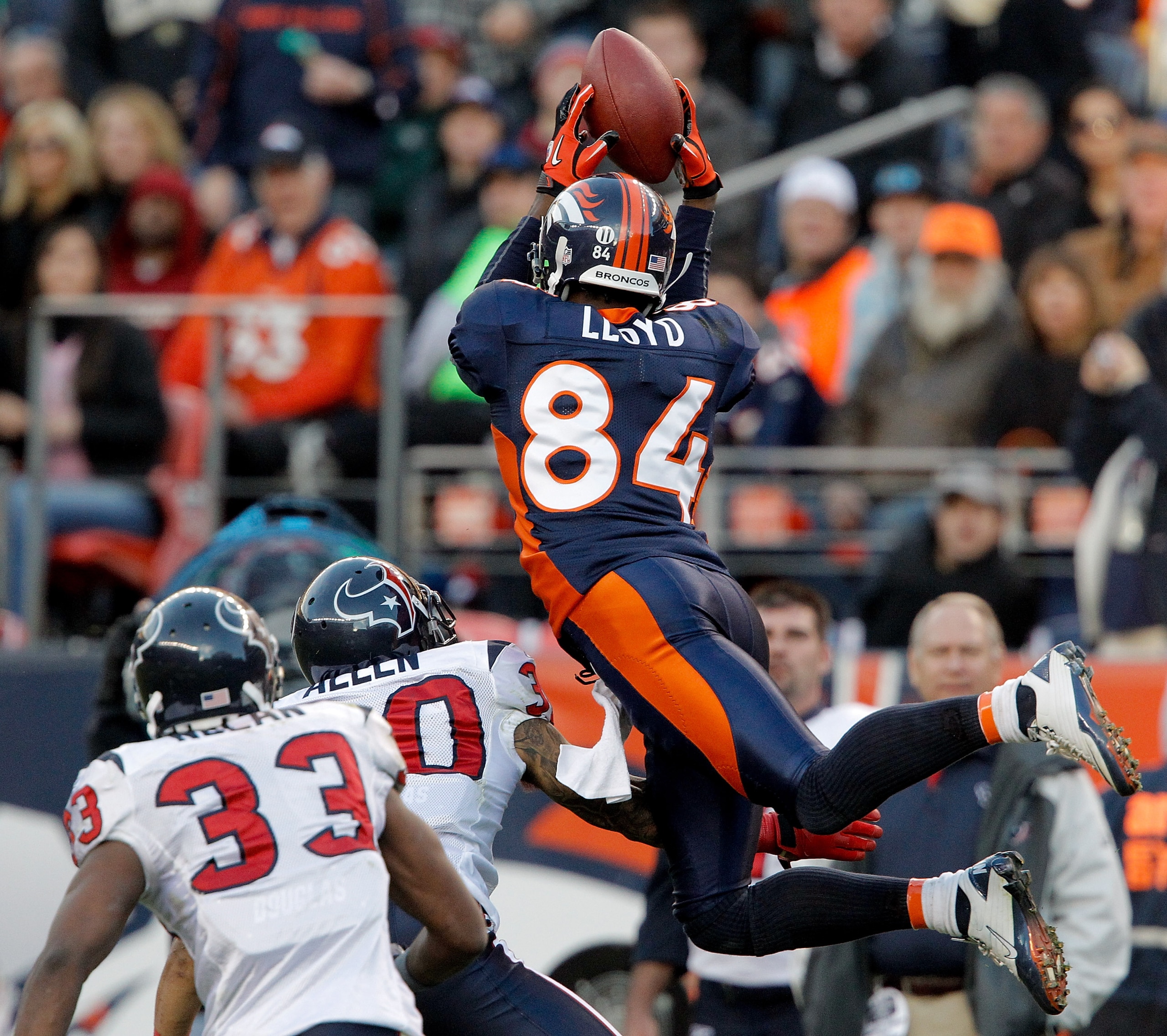 DENVER - DECEMBER 26:  Wide receiver Brandon Lloyd #84 of the Denver Broncos makes a leaping catch for a 41-yard reception against corner back Jason Allen #30 and safety Troy Nolan #33 of the Houston Texans during the third quarter at INVESCO Field at Mil