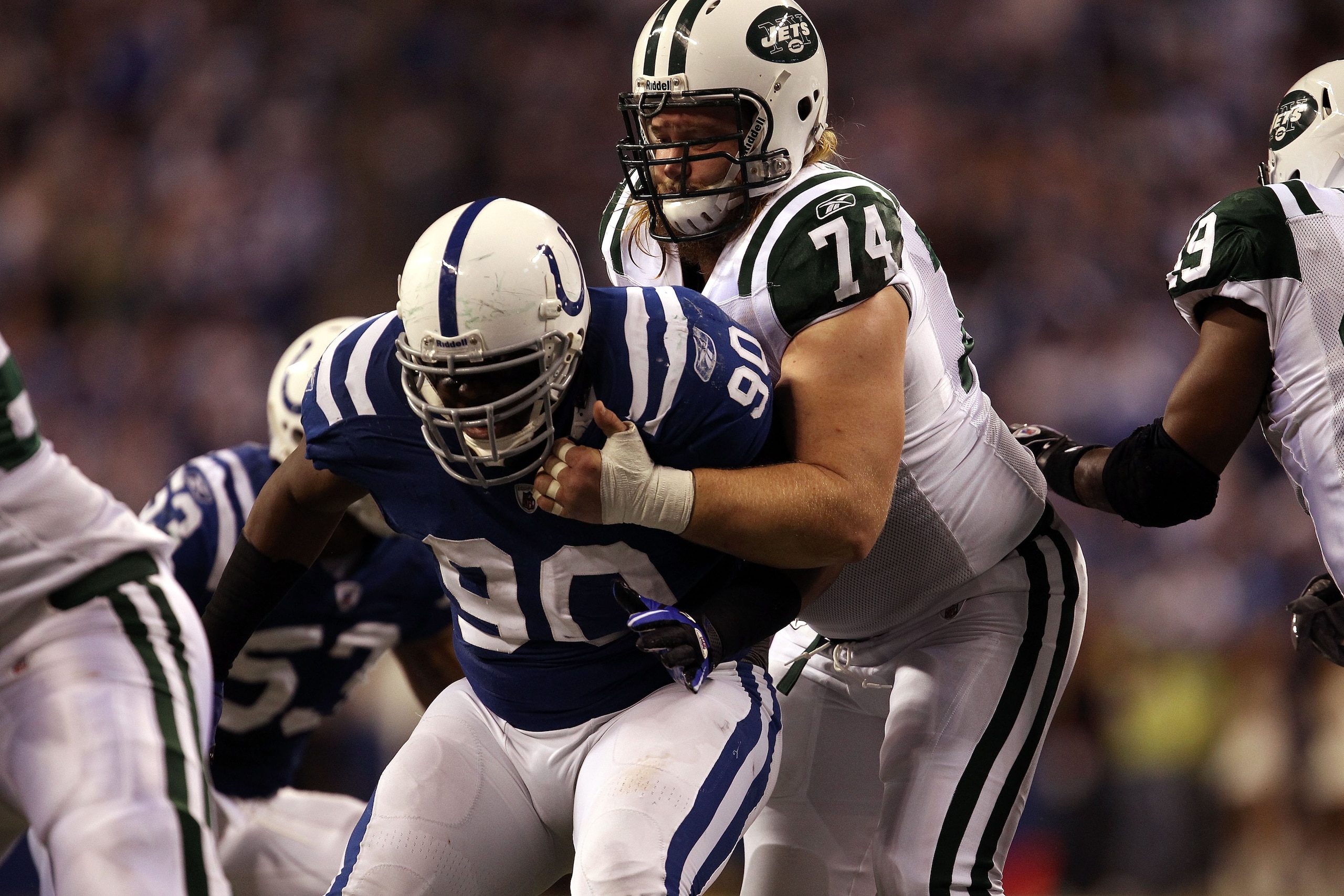 INDIANAPOLIS, IN - JANUARY 08:  Center Nick Mangold #74 of the New York Jets blocks against Dan Muir #90 of the Indianapolis Colts during their 2011 AFC wild card playoff game at Lucas Oil Stadium on January 8, 2011 in Indianapolis, Indiana. The Jets won
