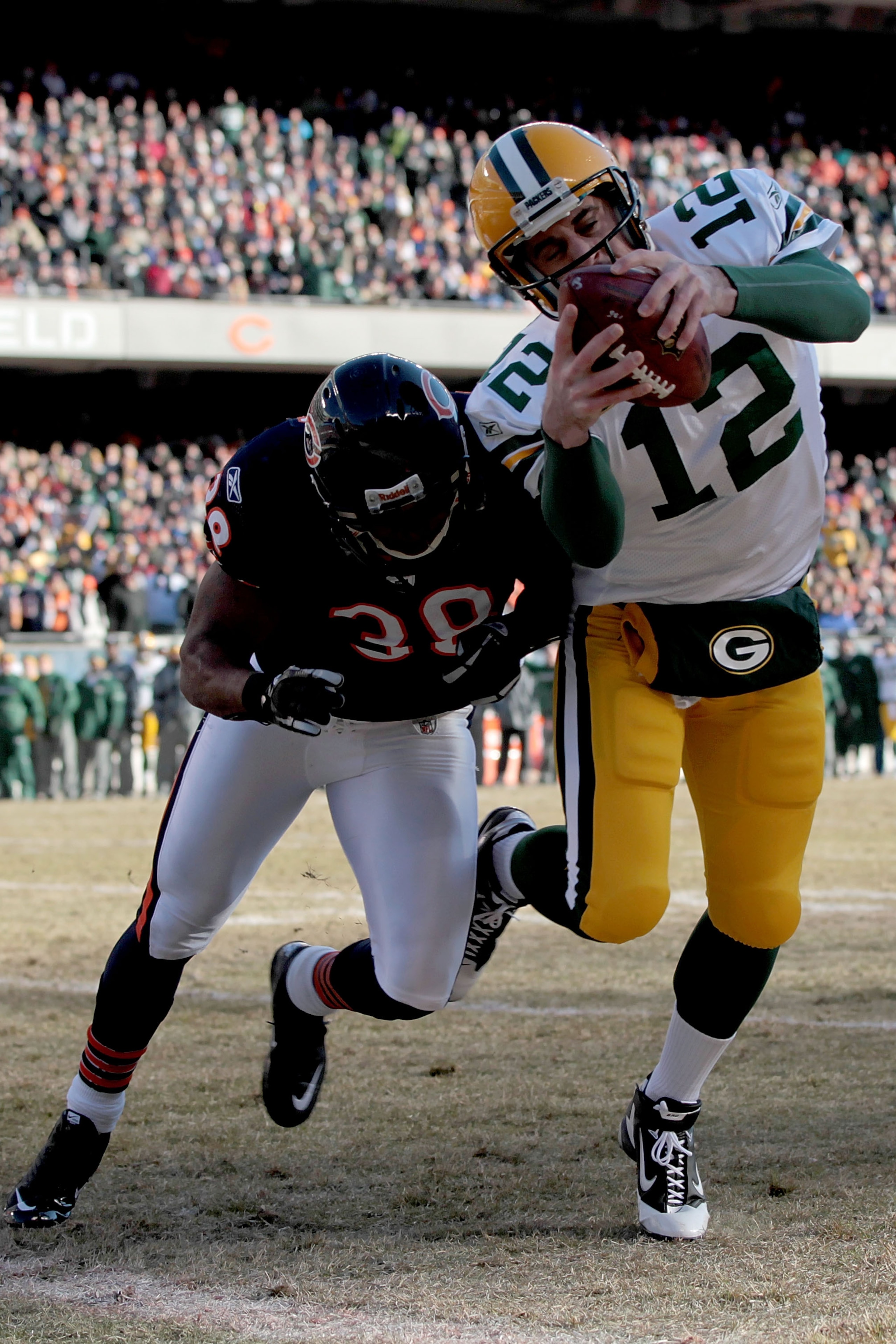 CHICAGO, IL - JANUARY 23:  Quarterback Aaron Rodgers #12 of the Green Bay Packers dives into the corner of the endzone for a one-yard touchdown run against Danieal Manning #38 of the Chicago Bears in the first quarter of the NFC Championship Game at Soldi