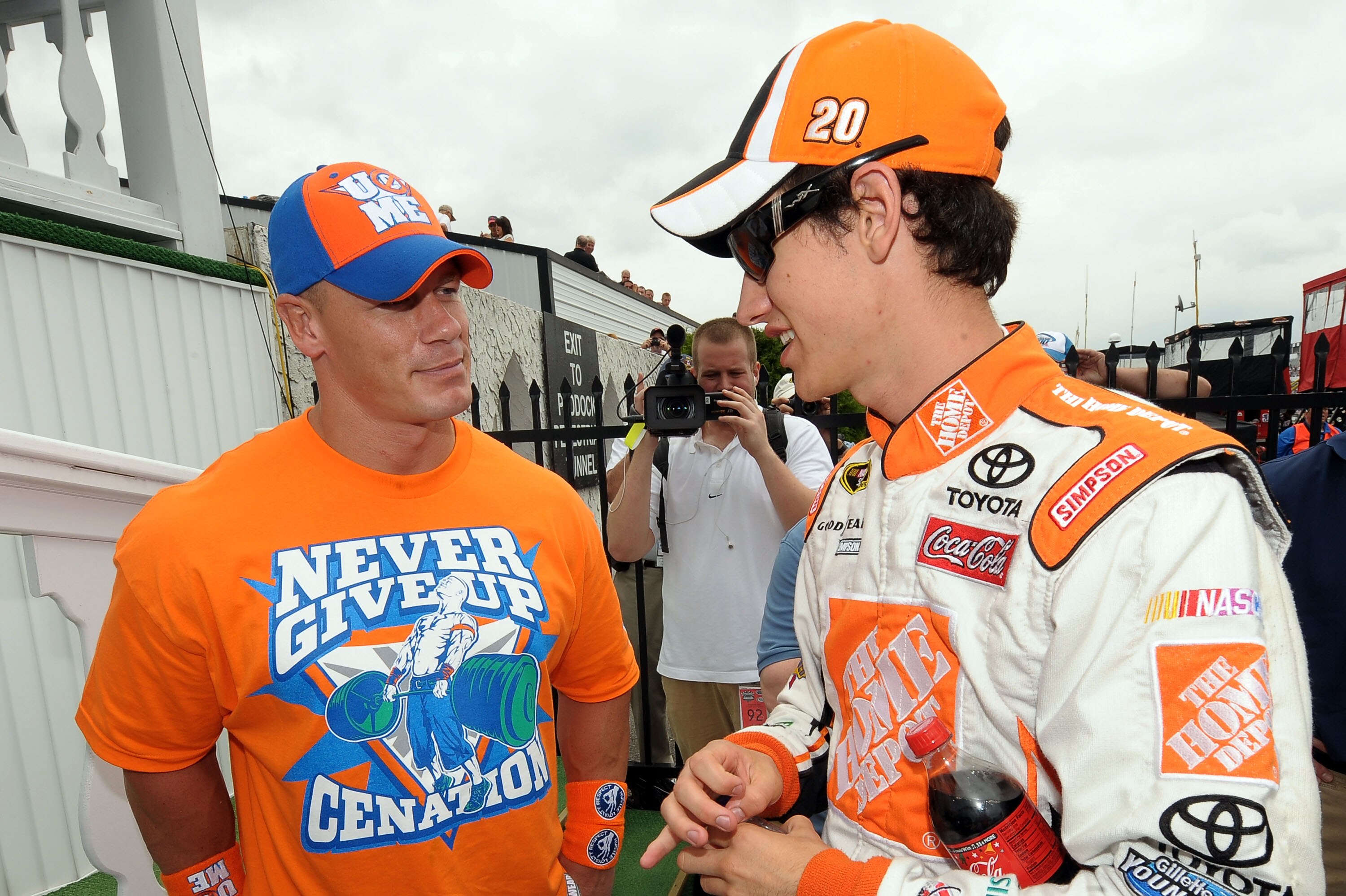 LONG POND, PA - JUNE 06:  WWE champion and co-grand marshal John Cena (L) and Joey Logano, driver of the #20 Home Depot Toyota, talk in Victory Lane prior to the NASCAR Sprint Cup Series Gillette Fusion ProGlide 500 at Pocono Raceway on June 6, 2010 in Lo