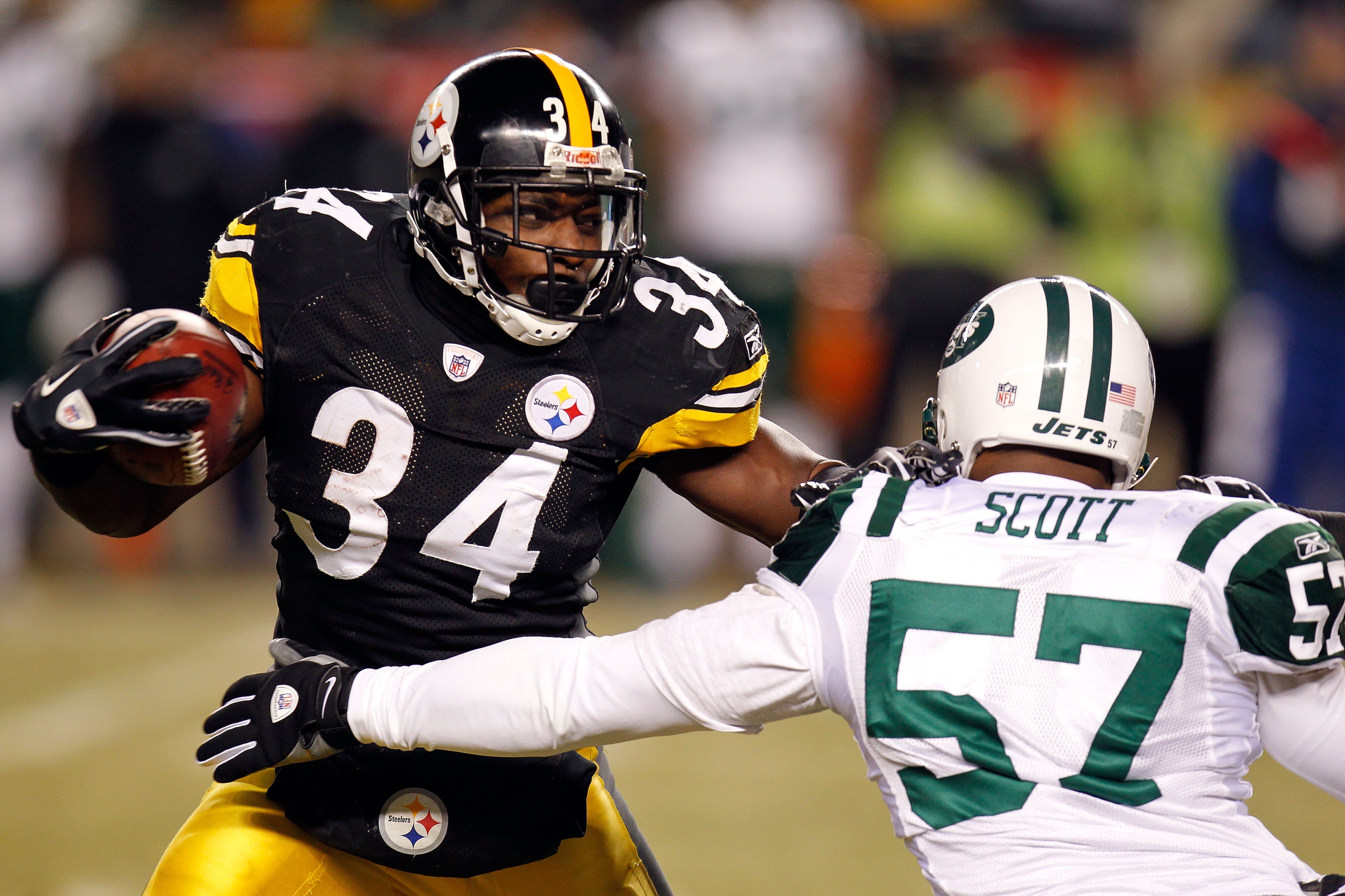 PITTSBURGH, PA - JANUARY 23:  Rashard Mendenhall #34 of the Pittsburgh Steelers runs down field against Bart Scott #57 of the New York Jets during the 2011 AFC Championship game at Heinz Field on January 23, 2011 in Pittsburgh, Pennsylvania.  (Photo by Gr