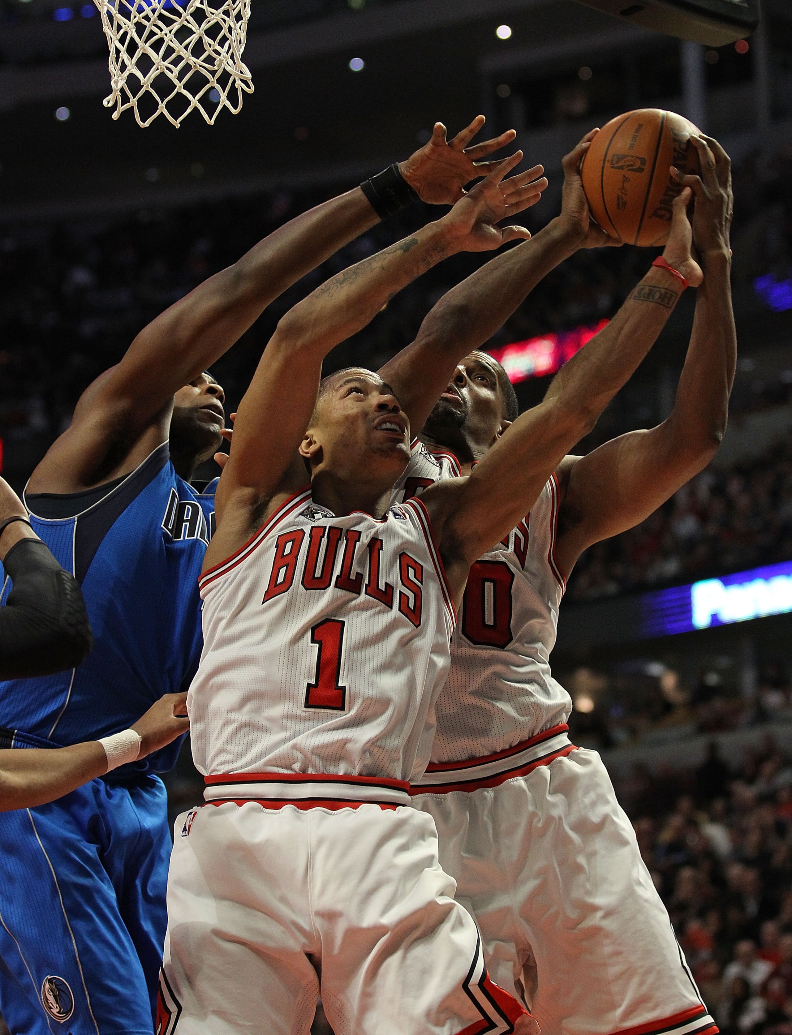 CHICAGO, IL - JANUARY 20: Derrick Rose #1 and Kurt Thomas #40 of the Chicago Bulls battle for a rebound with Brendan Haywood #33 of the Dallas Mavericks at the United Center on January 20, 2011 in Chicago, Illinois. The Bulls defeated the Mavericks 82-77.