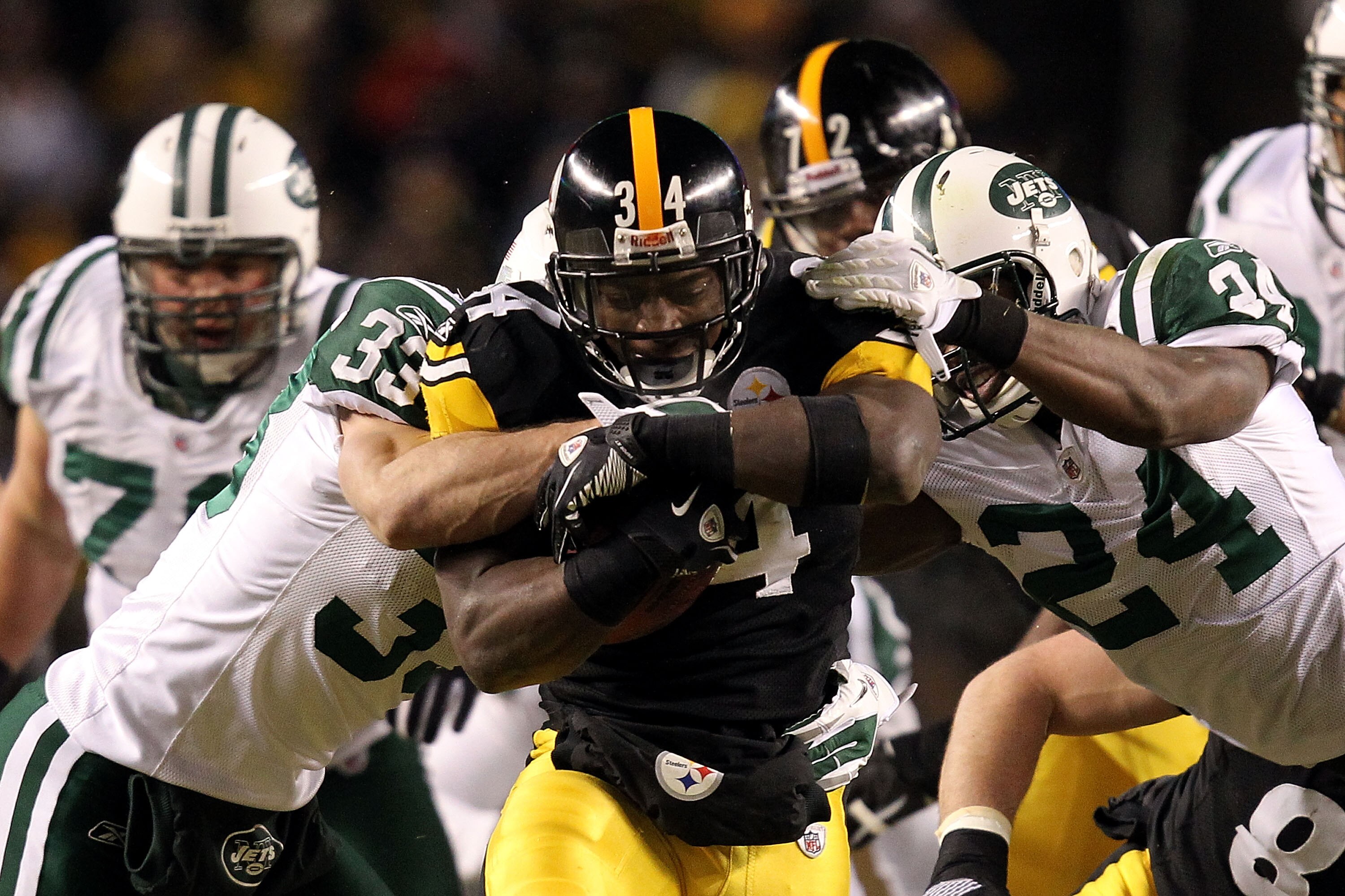 PITTSBURGH, PA - JANUARY 23:  Rashard Mendenhall #34 of the Pittsburgh Steelers tries to avoid the tackle of James Ihedigbo #44 and Darrelle Revis #24 of the New York Jets during the 2011 AFC Championship game at Heinz Field on January 23, 2011 in Pittsbu