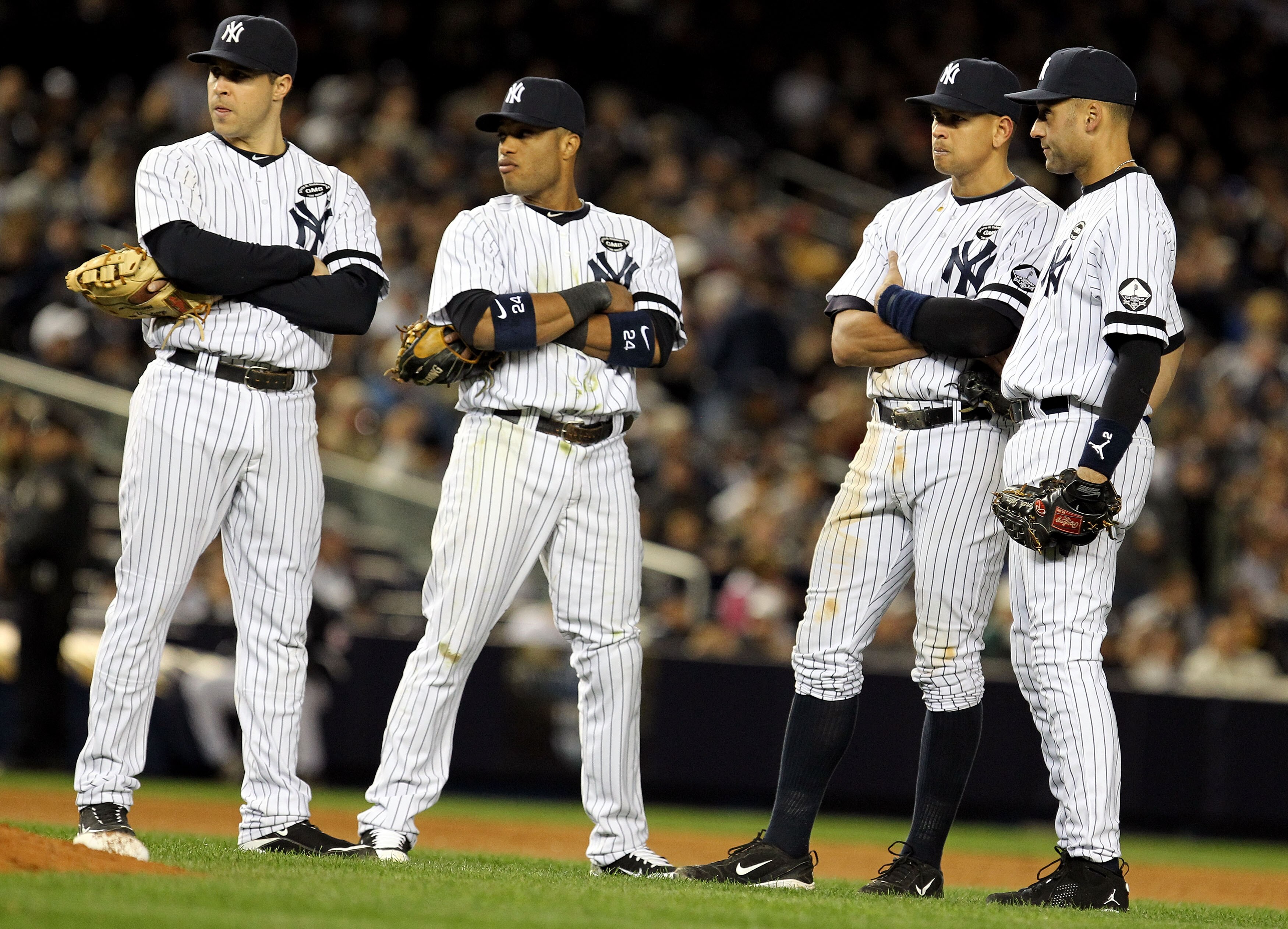 NEW YORK - OCTOBER 18:  Mark Teixeira #25, Robinson Cano #24, Alex Rodriguez #13 and Derek Jeter #2 of the New York Yankees look on during a pitching change against the Texas Rangers in Game Three of the ALCS during the 2010 MLB Playoffs at Yankee Stadium
