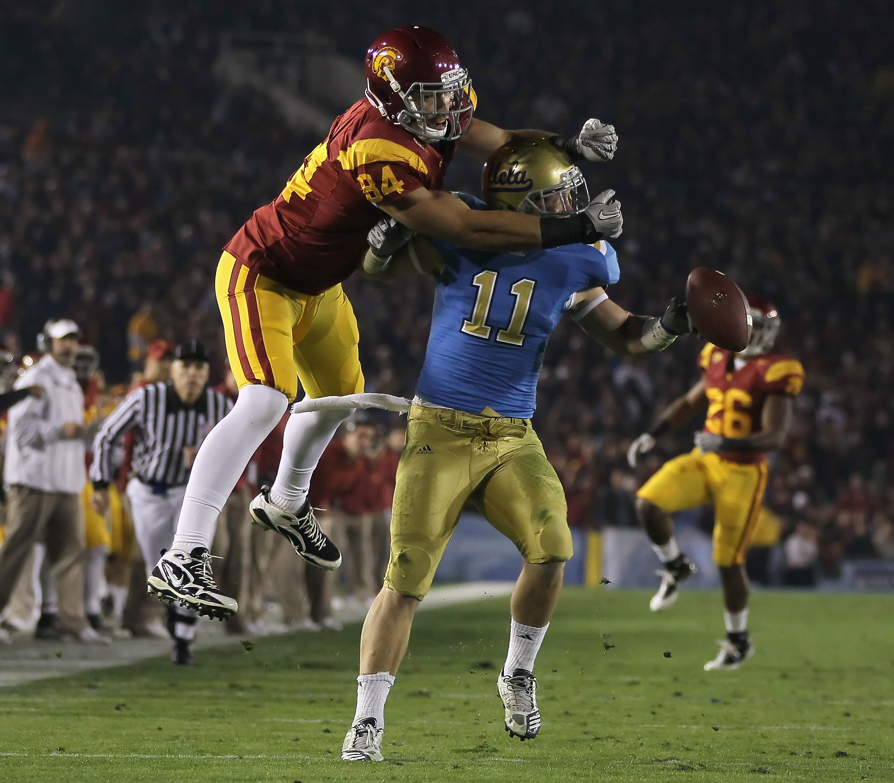 PASADENA, CA - DECEMBER 04:  Sean Westgate #11 of the UCLA Bruins breaks up a pass intended for Jordan Cameron #84 of the USC Trojans during the first half at the Rose Bowl on December 4, 2010 in Pasadena, California. USC defeated UCLA 28-14.  (Photo by J