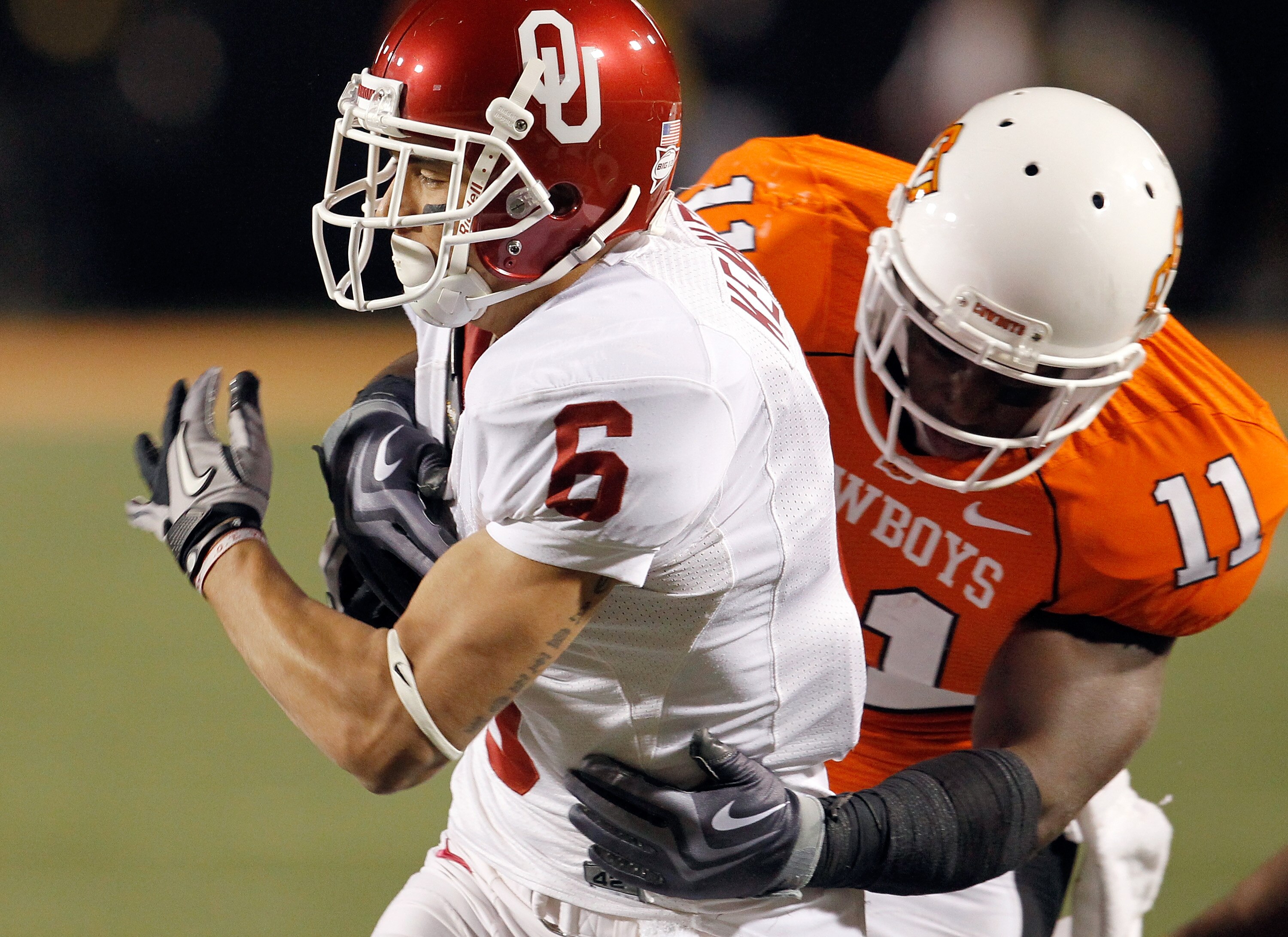 STILLWATER, OK - NOVEMBER 27:  Wide receiver Cameron Kenney #6 of the Oklahoma Sooners carries the ball against linebacker Shaun Lewis #11 of the Oklahoma State Cowboys at Boone Pickens Stadium on November 27, 2010 in Stillwater, Oklahoma.  The Sooners be