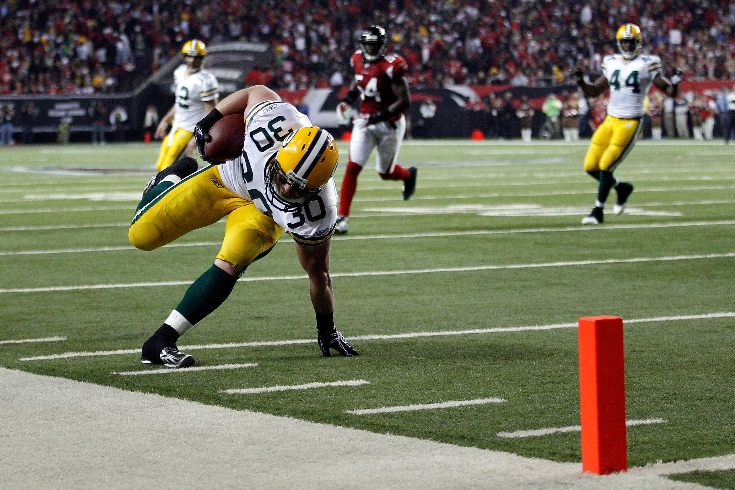 ATLANTA, GA - JANUARY 15: John Kuhn #30 of the Green Bay Packers scores a 7-yard touchdown reception against the Atlanta Falcons during their 2011 NFC divisional playoff game at Georgia Dome on January 15, 2011 in Atlanta, Georgia. (Photo by Chris Grayt ATLANTA, GA - JANUARY 15: John Kuhn #30 of the Green Bay Packers scores a 7-yard touchdown reception against the Atlanta Falcons during their 2011 NFC divisional playoff game at Georgia Dome on January 15, 2011 in Atlanta, Georgia. (Photo by Chris Grayt