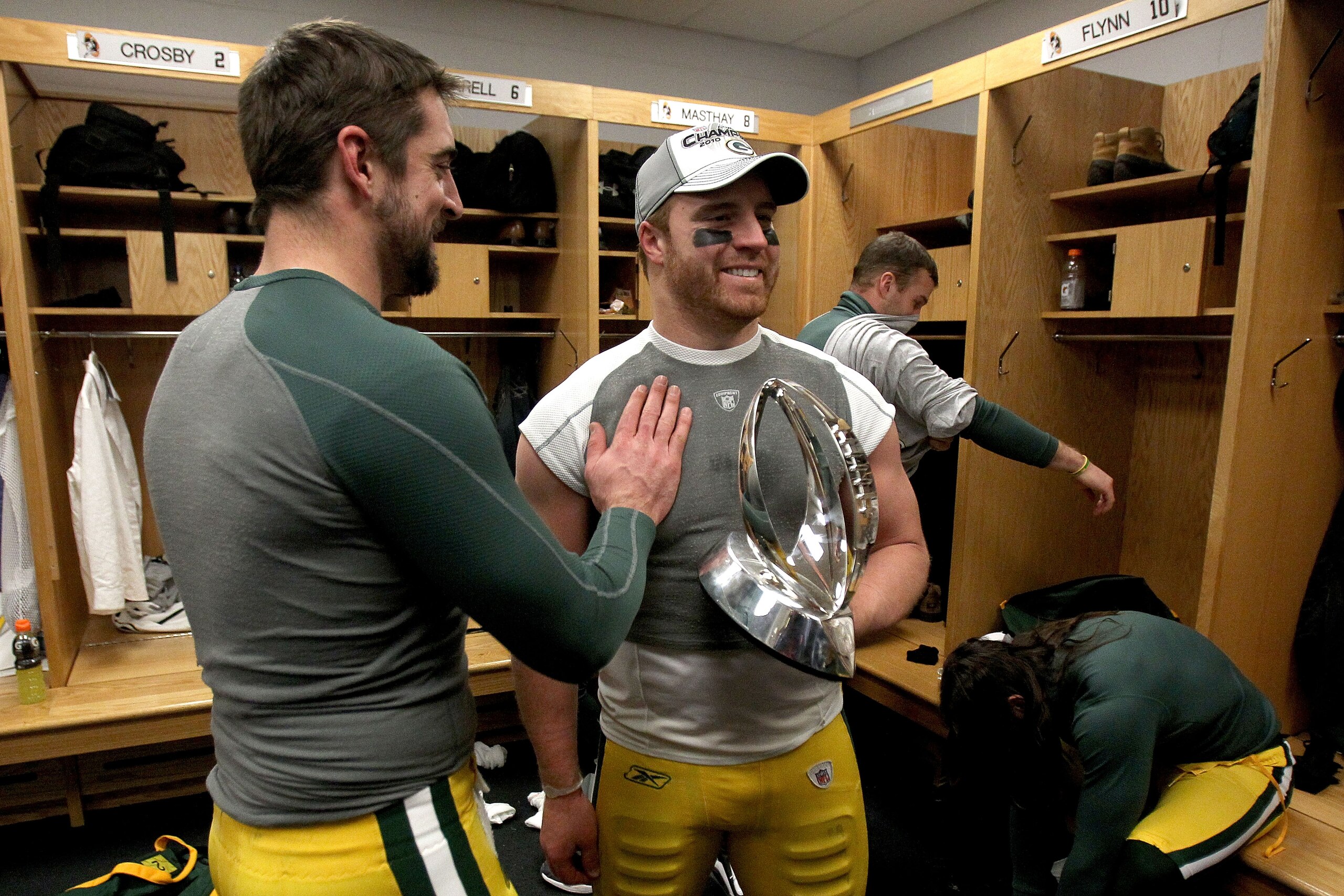 CHICAGO, IL - JANUARY 23:  (L-R) Quarterback Aaron Rodgers #12 and John Kuhn #30 of the Green Bay Packers celebrate the Packers 21-14 victory against the Chicago Bears with the George Halas Trophy after the NFC Championship Game at Soldier Field on Januar