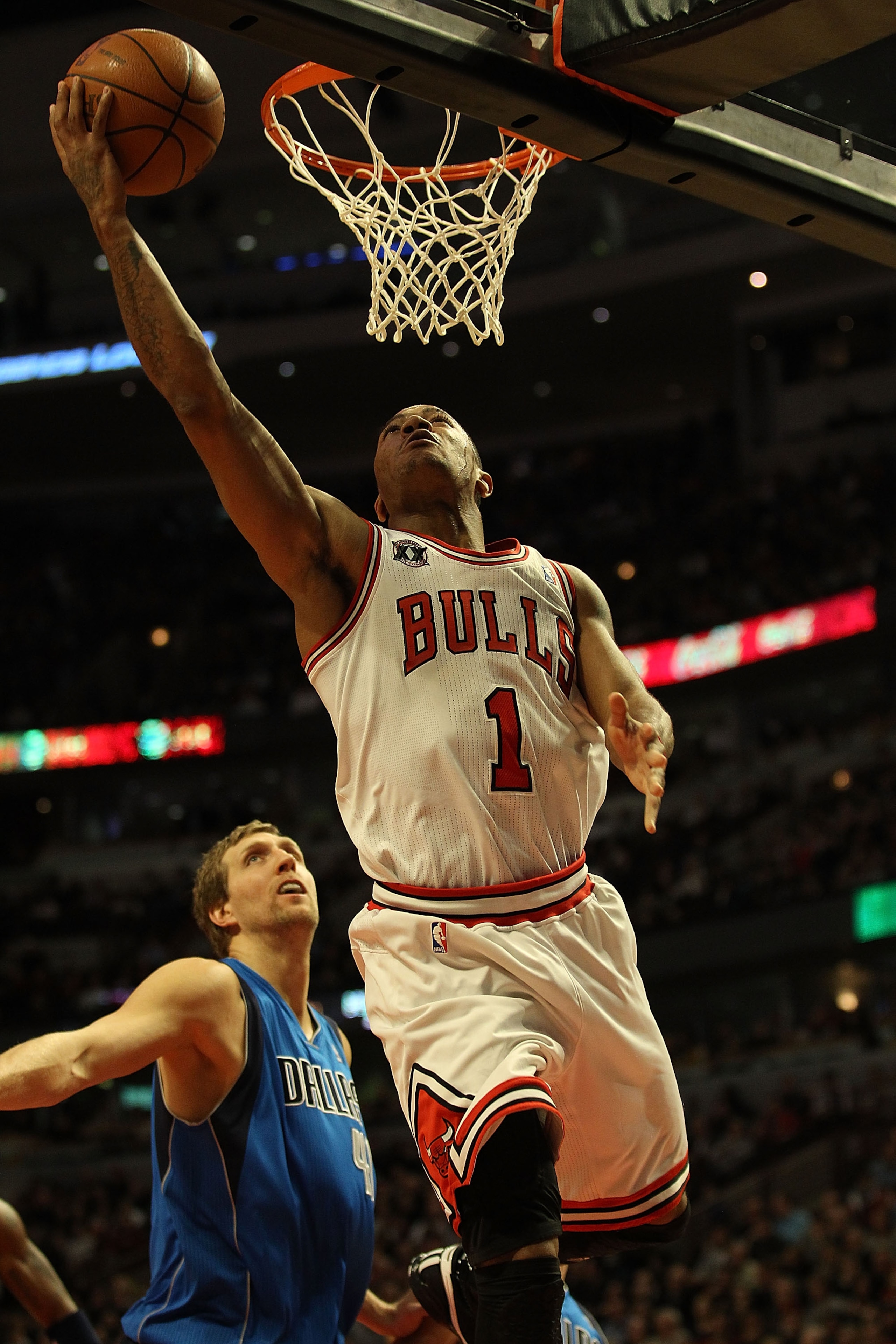 CHICAGO, IL - JANUARY 20: Derrick Rose #1 of the Chicago Bulls goes up for a shot past Dirk Nowitzki #41 of the Dallas Mavericks on his way to a game-high 26 points at the United Center on January 20, 2011 in Chicago, Illinois. The Bulls defeated the Mave