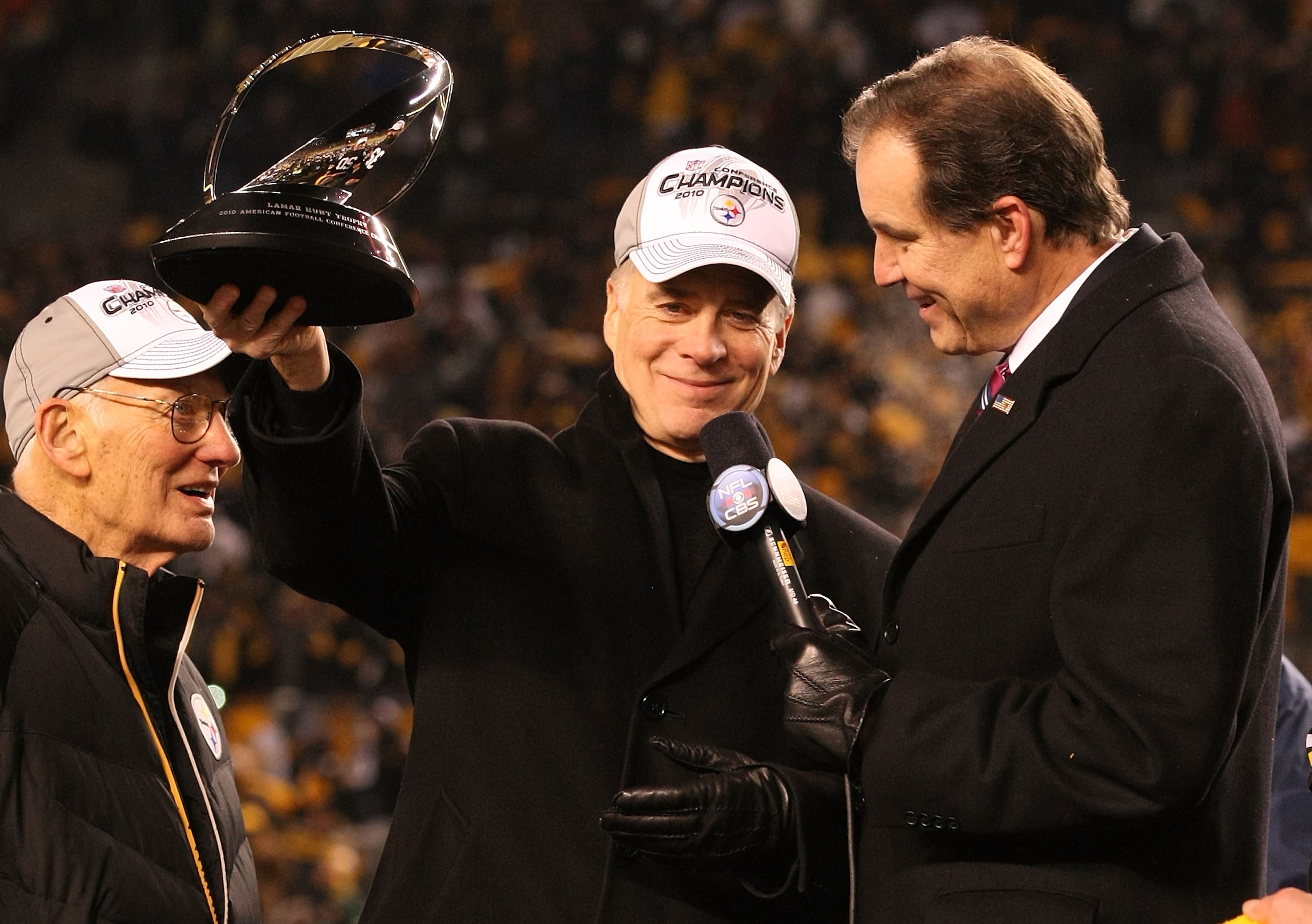 PITTSBURGH, PA - JANUARY 23:  Owner Dan Rooney (L) and Team president Art Rooney II (2ndL) of the Pittsburgh Steelers recieve the Lamar Hunt Trophy as CBS sportscaster Jim Nantz looks on after their 24 to 19 win over the New York Jets in the 2011 AFC Cham