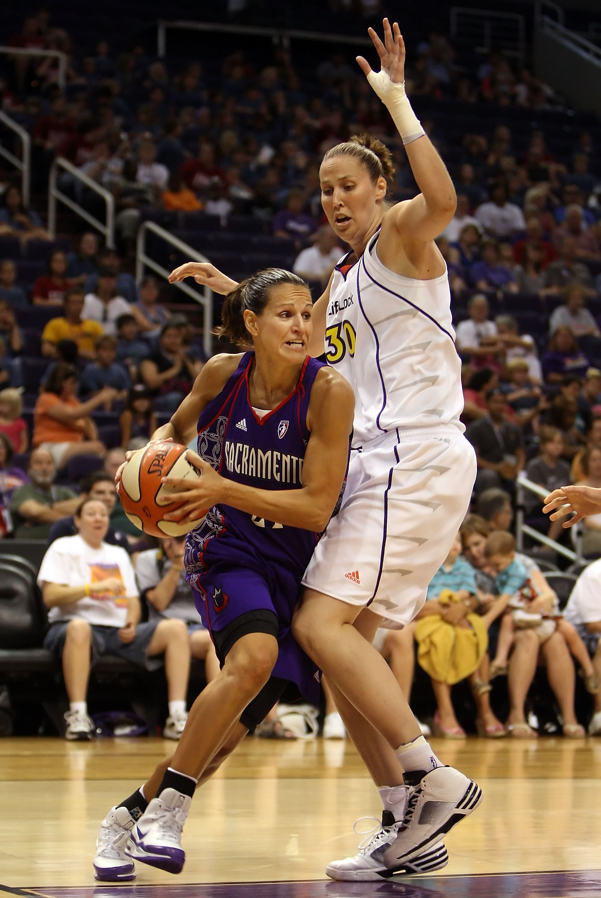 PHOENIX - JULY 15:  Ticha Penicheiro #21 of the Sacramento Monarchs drives with the ball past Nicole Ohlde #30 of the Phoenix Mercury during the WNBA game at US Airways Center on July 15, 2009 in Phoenix, Arizona. NOTE TO USER: User expressly acknowledges