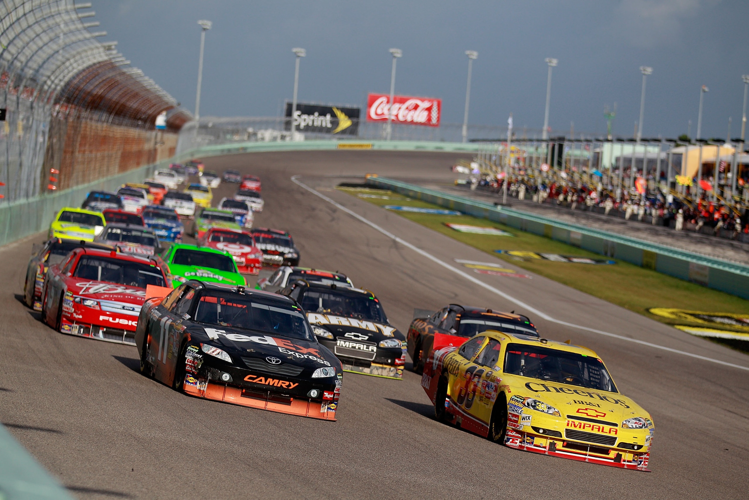 HOMESTEAD, FL - NOVEMBER 21:  Denny Hamlin, driver of the #11 FedEx Toyota, and Clint Bowyer, driver of the #33 Cheerios Chevrolet, lead a group of cars during the NASCAR Sprint Cup Series Ford 400 at Homestead-Miami Speedway on November 21, 2010 in Homes
