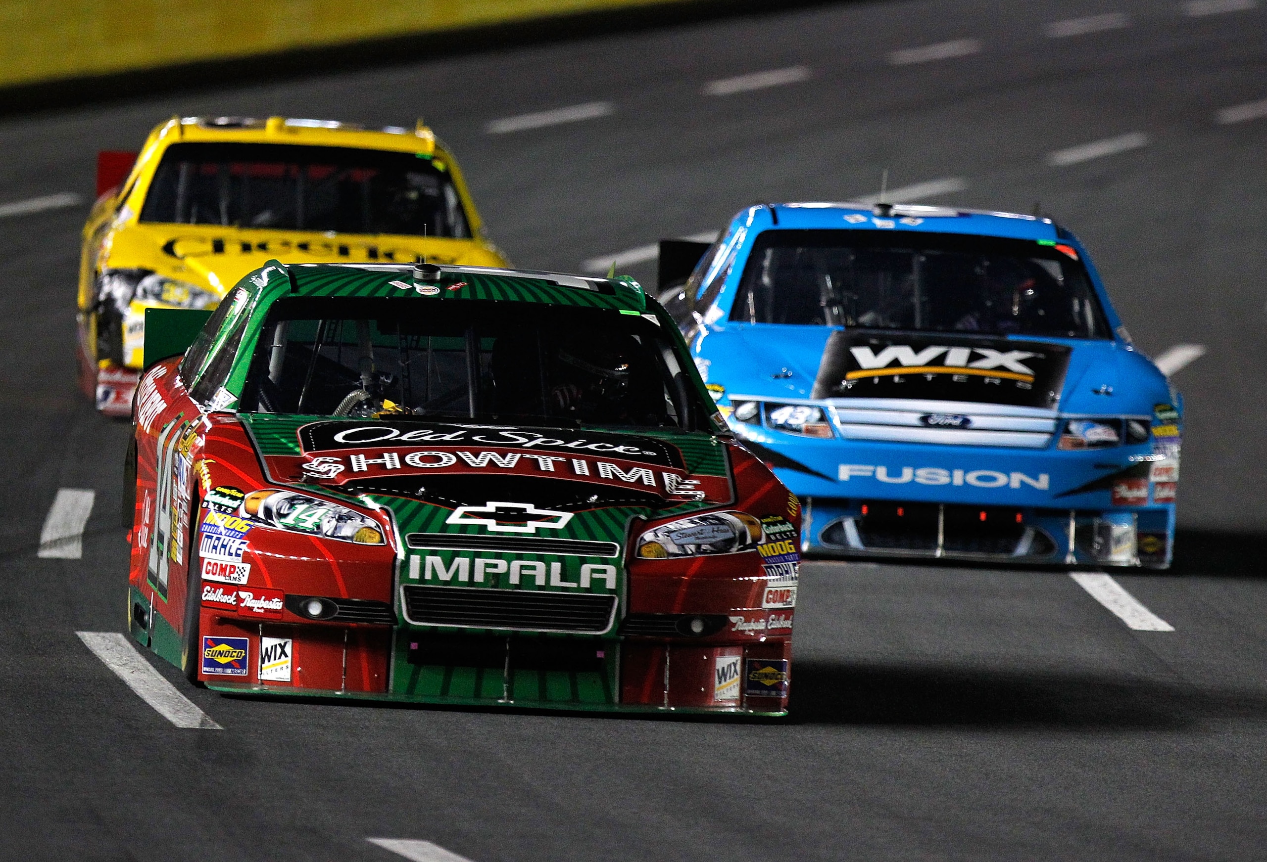 CONCORD, NC - OCTOBER 16:  Tony Stewart, driver of the #14 Showtime Old Spice Chevrolet leads AJ Allmendinger, driver of the #43 WIX Filters Ford, and Clint Bowyer, driver of the #33 Hamburger Helper/Cheerios Chevrolet during the NASCAR Sprint Cup Series