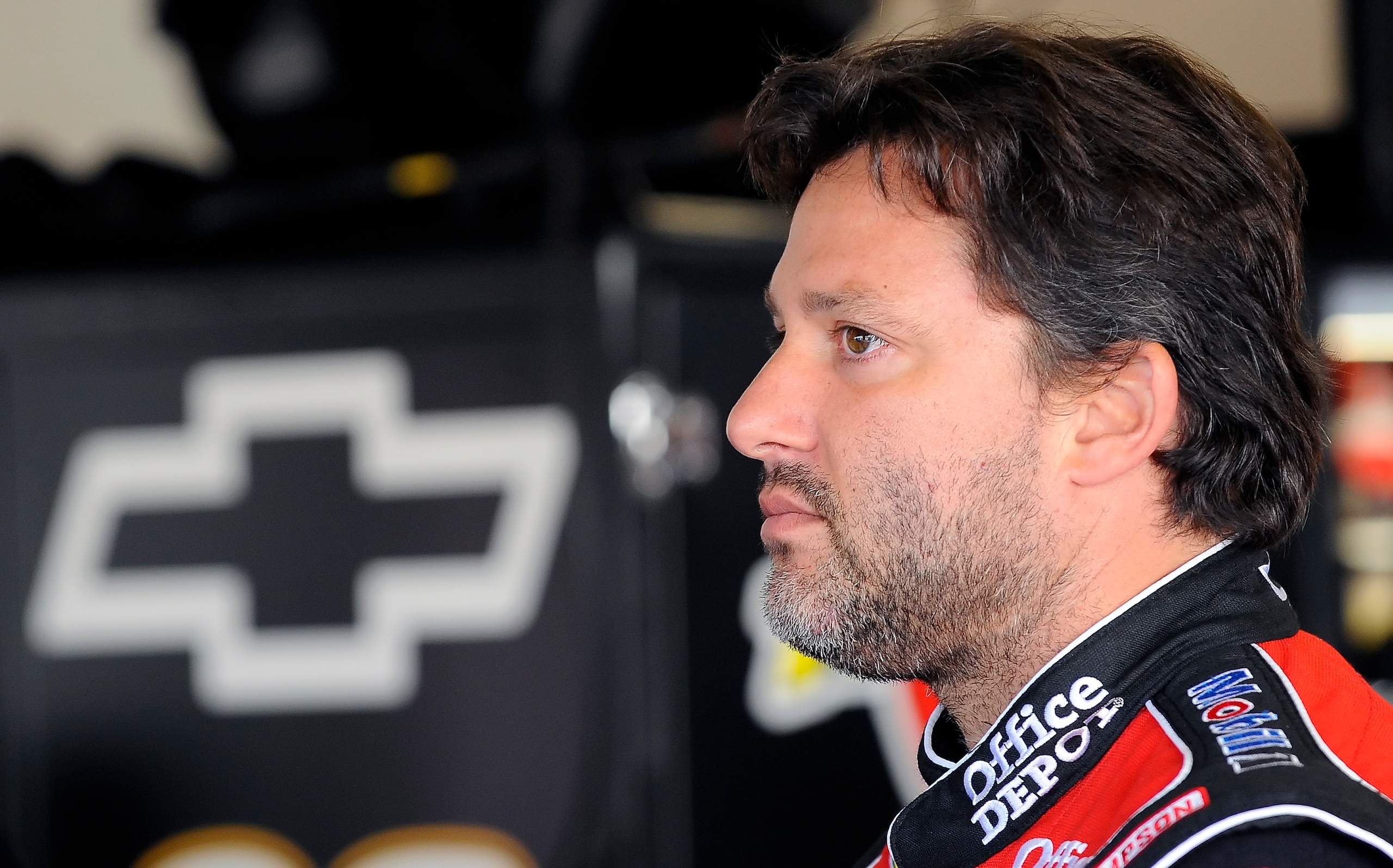 DAYTONA BEACH, FL - JANUARY 22:  Tony Stewart, driver of the #14 Office Depot/Mobil 1 Chevrolet, stands in the garage are prior to testing at Daytona International Speedway on January 22, 2011 in Daytona Beach, Florida.  (Photo by Jared C. Tilton/Getty Im