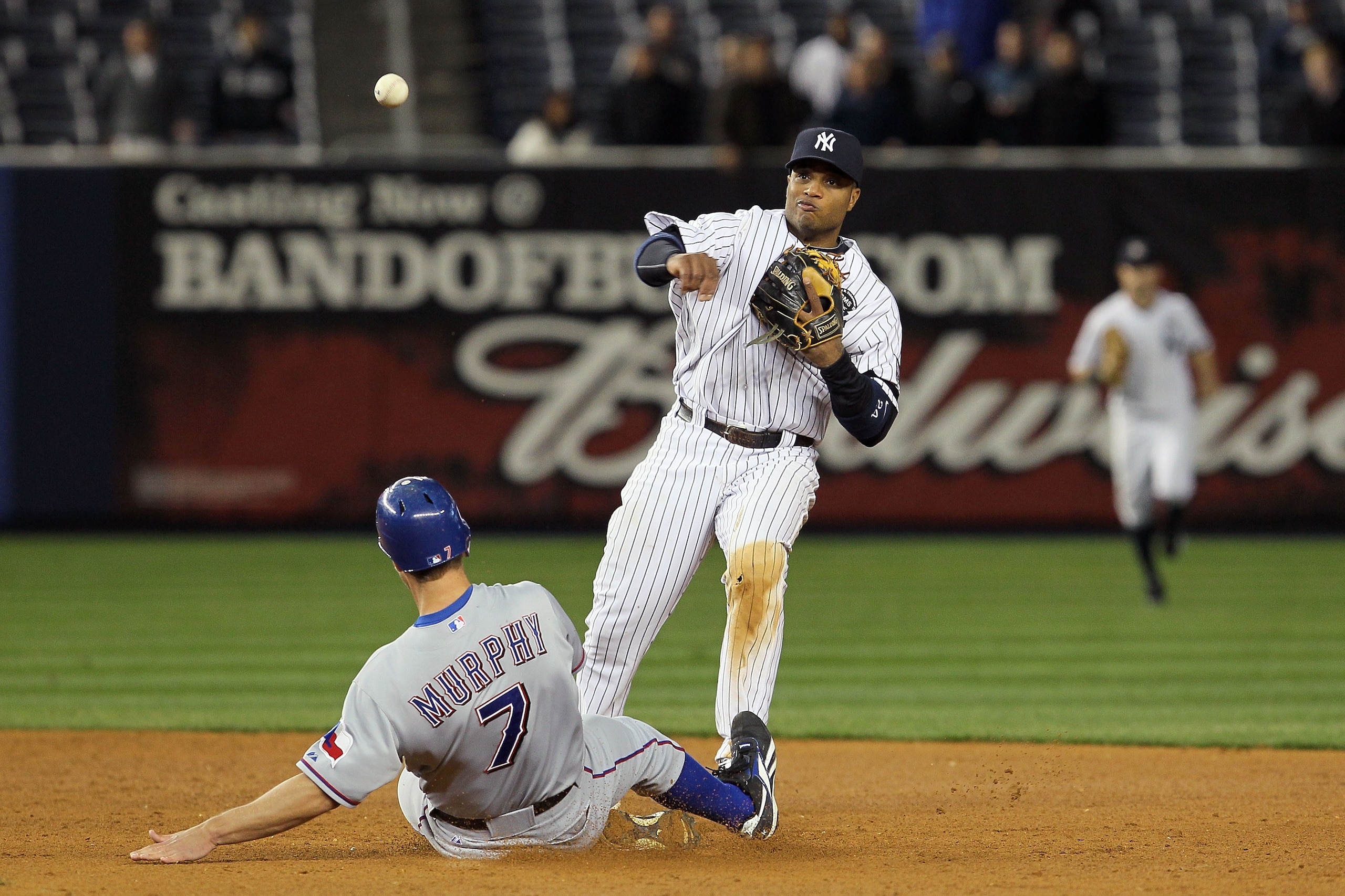 NEW YORK - OCTOBER 19: Robinson Cano #24 of the New York Yankees turns a successful double play in the ninth inning over a sliding David Murphy #7 of the Texas Rangers in Game Four of the ALCS during the 2010 MLB Playoffs at Yankee Stadium on October 19, NEW YORK - OCTOBER 19: Robinson Cano #24 of the New York Yankees turns a successful double play in the ninth inning over a sliding David Murphy #7 of the Texas Rangers in Game Four of the ALCS during the 2010 MLB Playoffs at Yankee Stadium on October 19,