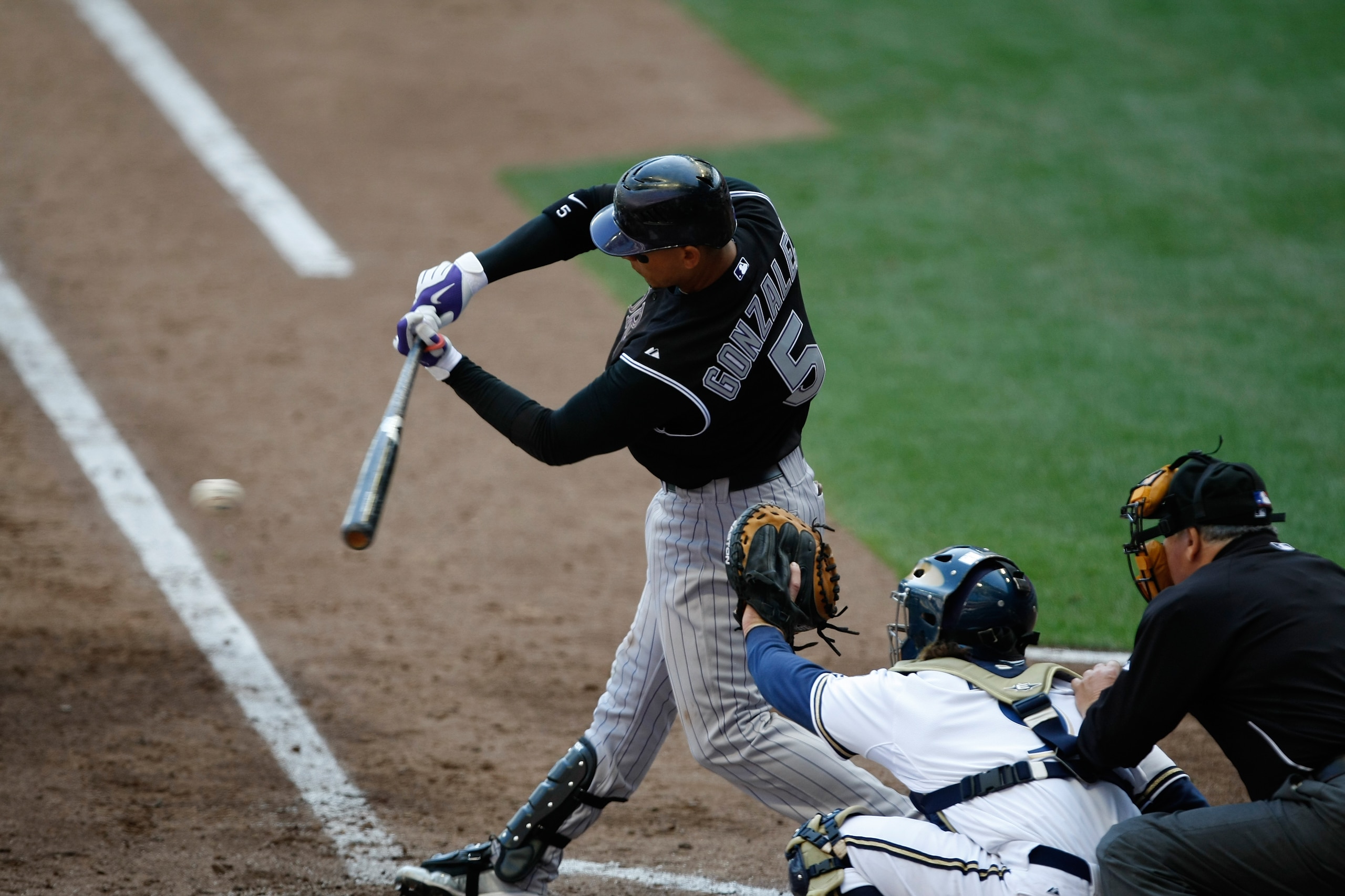MILWAUKEE, WI - APRIL 05: Outfielder Carlos Gonzalez #5 of the Colorado Rockies follows through on his swing after hitting the baseball against the Milwaukee Brewers at the Miller Park on April 05, 2010 in Milwaukee, Wisconsin. The Rockies defeated the Br